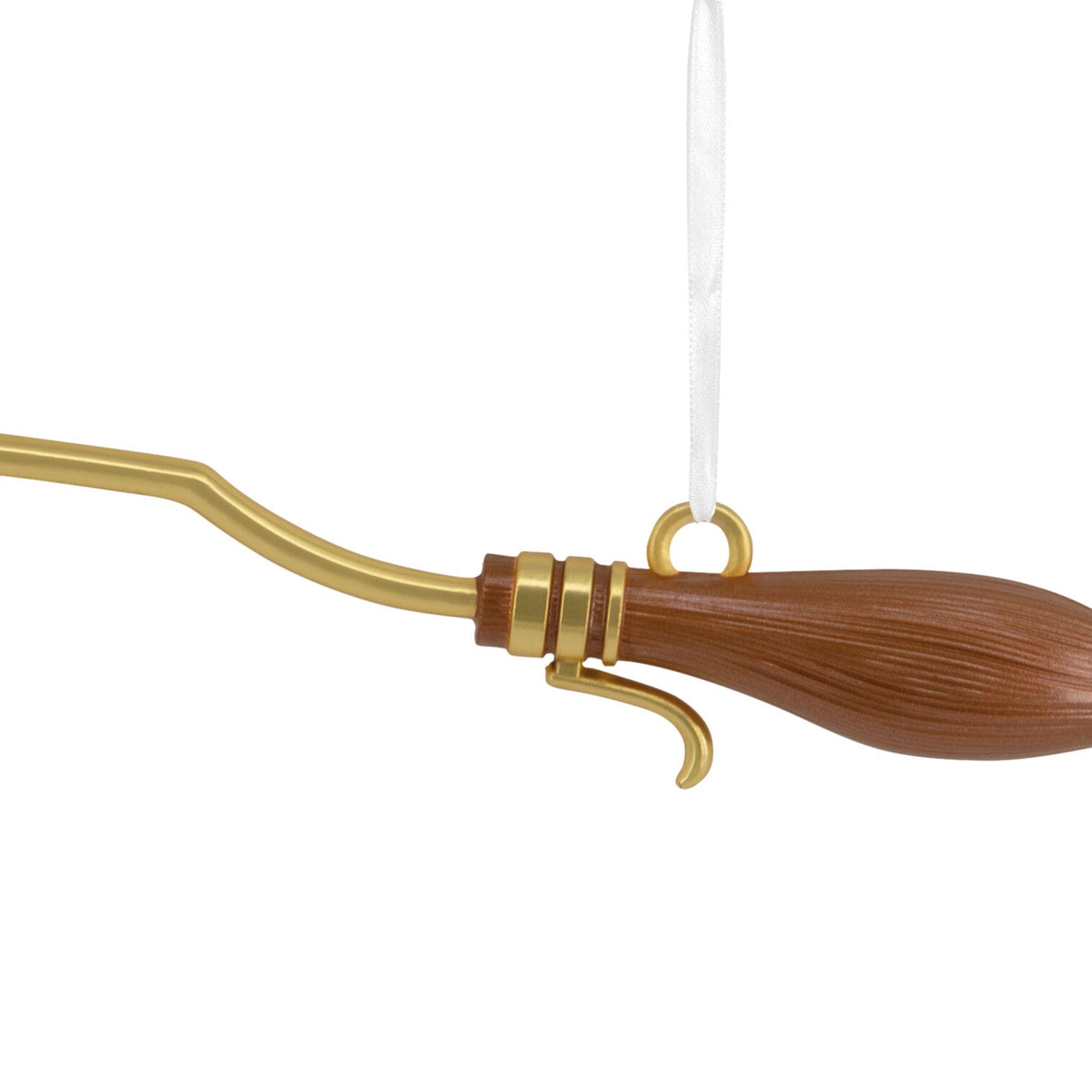 A close-up of a golden broomstick ornament