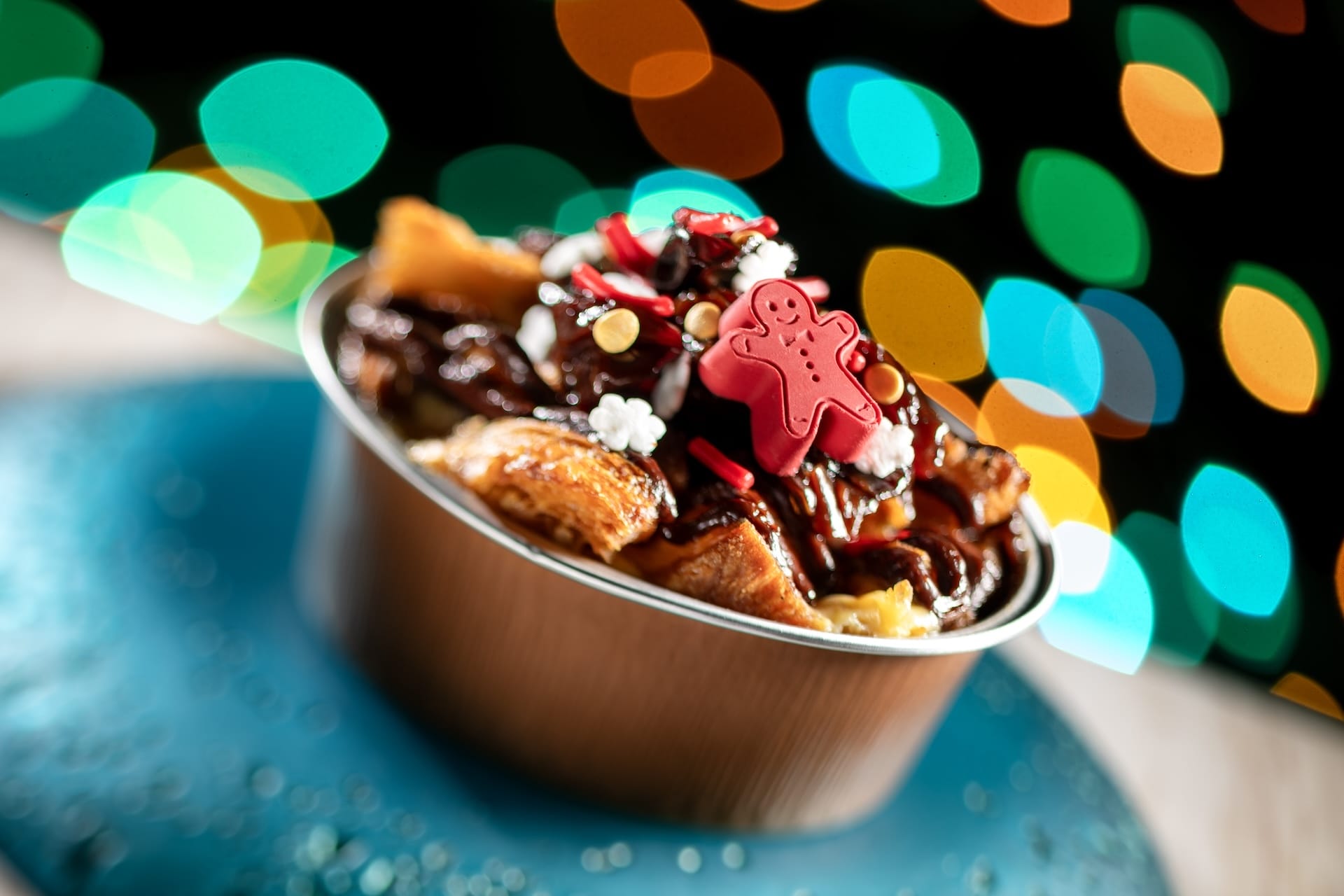 Dessert in a bowl with chocolate sauce and red gingerbread man candy, served at Disney Jollywood Nights 2025 in the theme park.