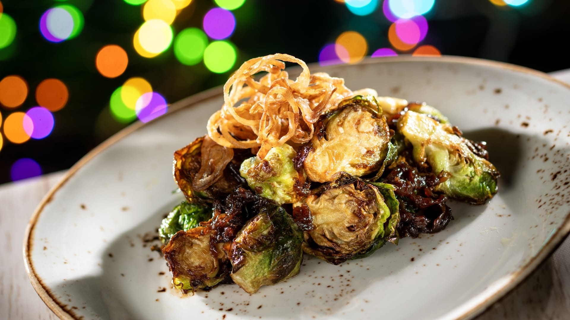 Crispy fried onions on roasted Brussels sprouts, a savory new dish at Disney Jollywood Nights 2025 food event—no castle pictured.