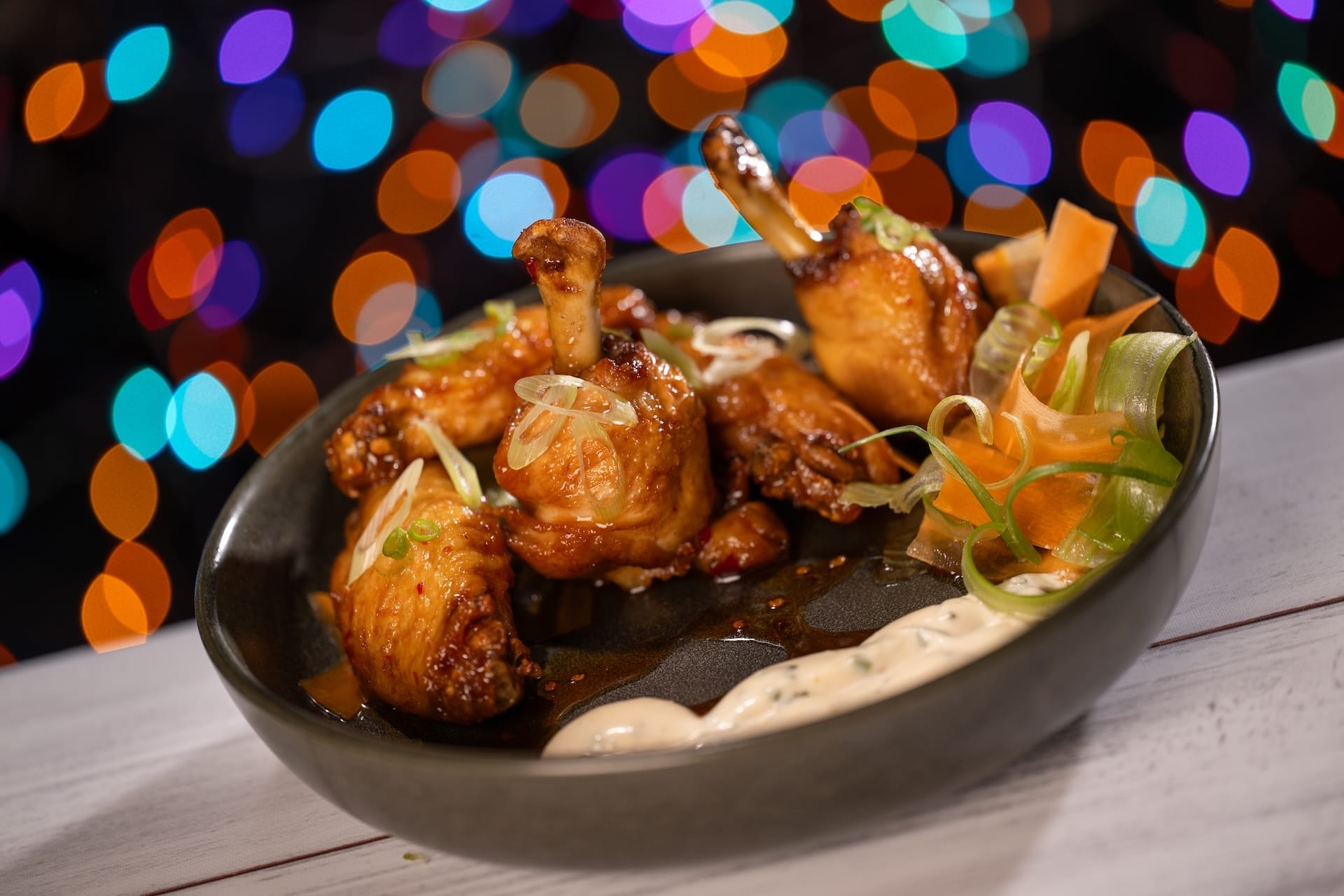 Glazed chicken drumettes from Disney Jollywood Nights, served with dip and veggies, a festive bite found at Disney Parks events.