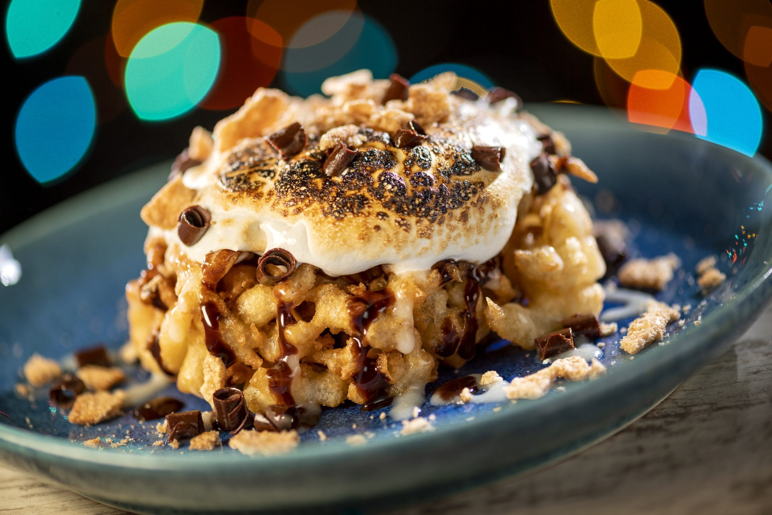 A Disney Jollywood Nights-inspired dessert with toasted marshmallow and chocolate shavings, reminiscent of park-exclusive treats.