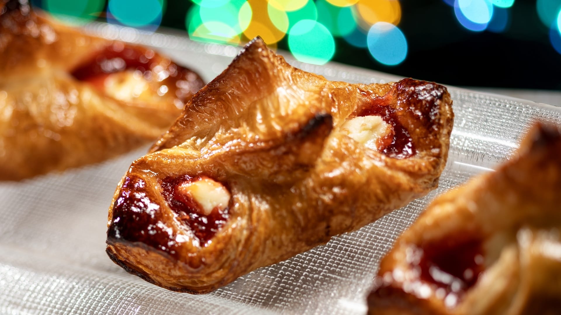 Close-up of flaky fruit jam and cream pastries, a festive Disney Jollywood Nights 2025 treat, reminiscent of Main Street bakeries.