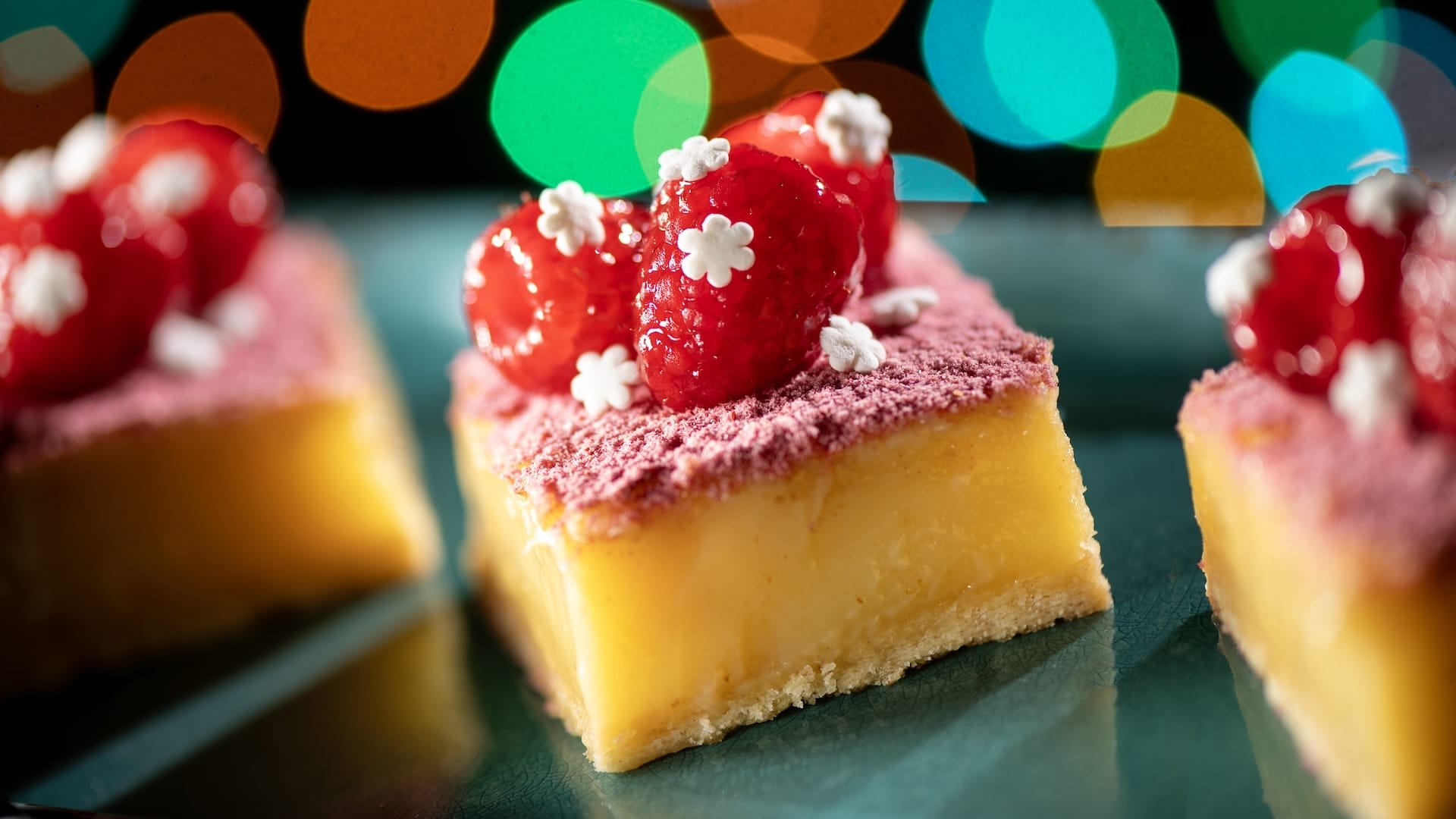 A lemon bar with raspberries and sprinkles, inspired by Disney Jollywood Nights treats found at Disney Parks worldwide for 2025.