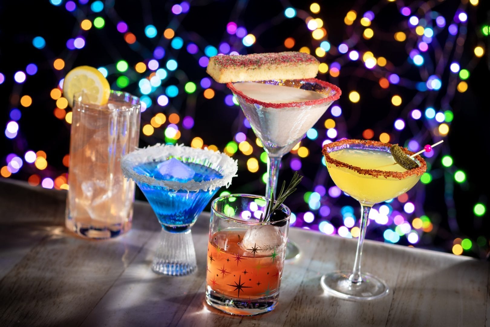 Four vibrant cocktails on a table, inspired by Disney park festivities—ideal for Jollywood Nights or 2025 food event tastings.