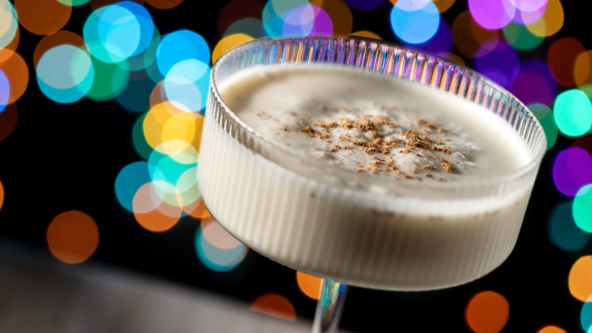 A festive glass of creamy eggnog with nutmeg, ideal for Disney Jollywood Nights 2025 at the parks—no castle in this shot.
