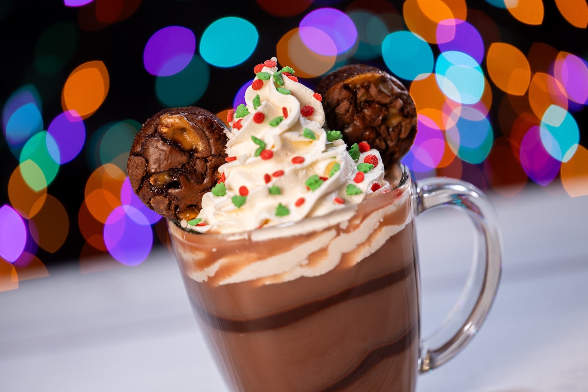 A festive hot chocolate with whipped cream and brownies, ideal for Disney Jollywood Nights 2025—no castle like Cinderella’s in sight.