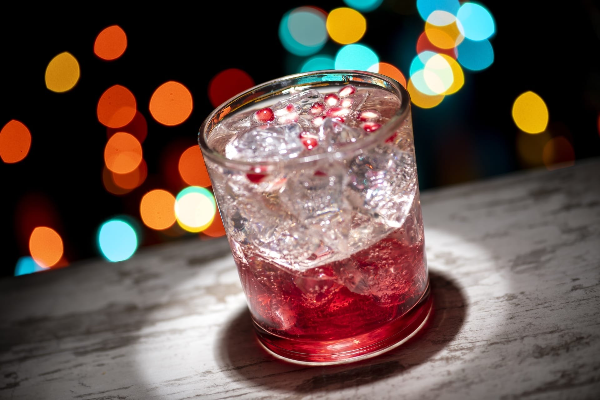 A festive red cocktail with ice and pomegranate seeds, ideal for toasting Disney Jollywood Nights at Walt Disney World in 2025.
