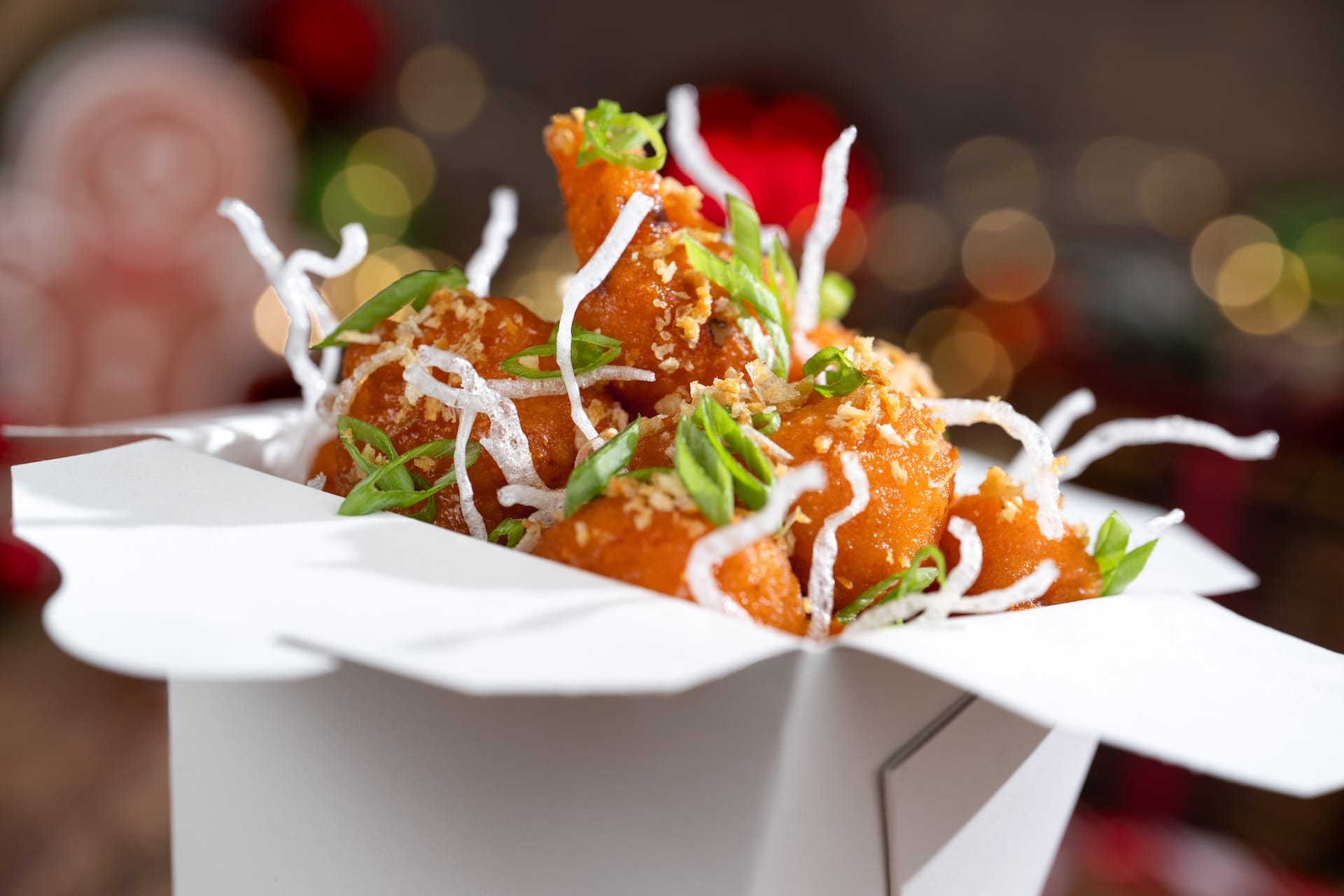 Crispy fried shrimp with green onions and crunchy noodles, Holiday Menu item in a festive white takeout box at Disney Park.