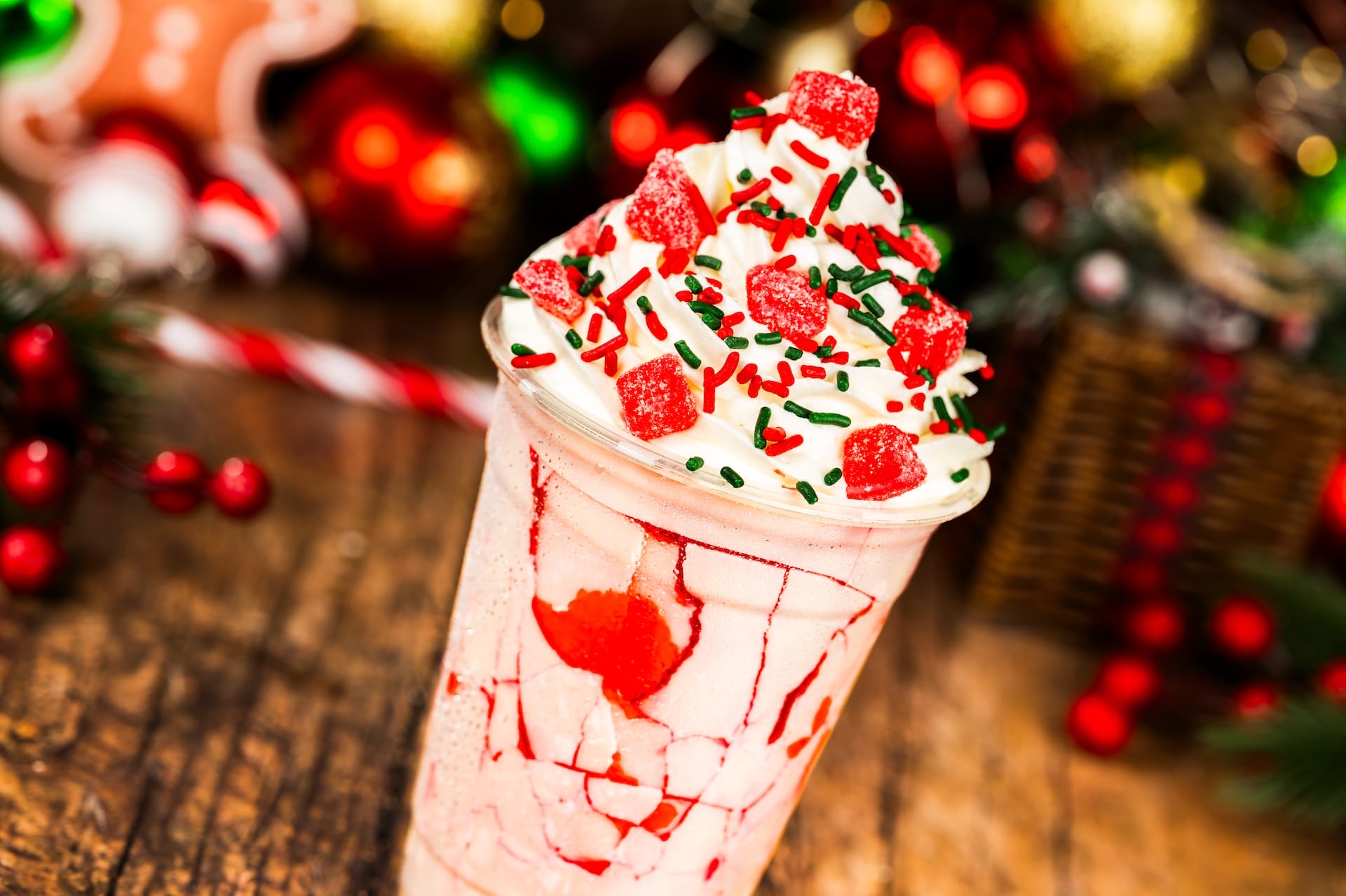 A festive milkshake with whipped cream, red syrup, and green sprinkles—just like a holiday treat at the Disney Parks.