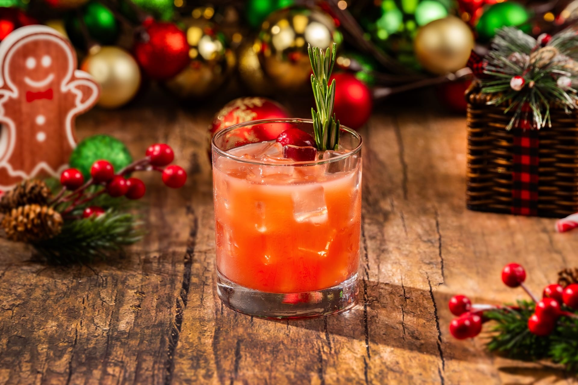 Holiday cocktail with ice, cranberries, and rosemary—festive refreshment for Mickey’s Very Merry Christmas Party at Disney Parks.