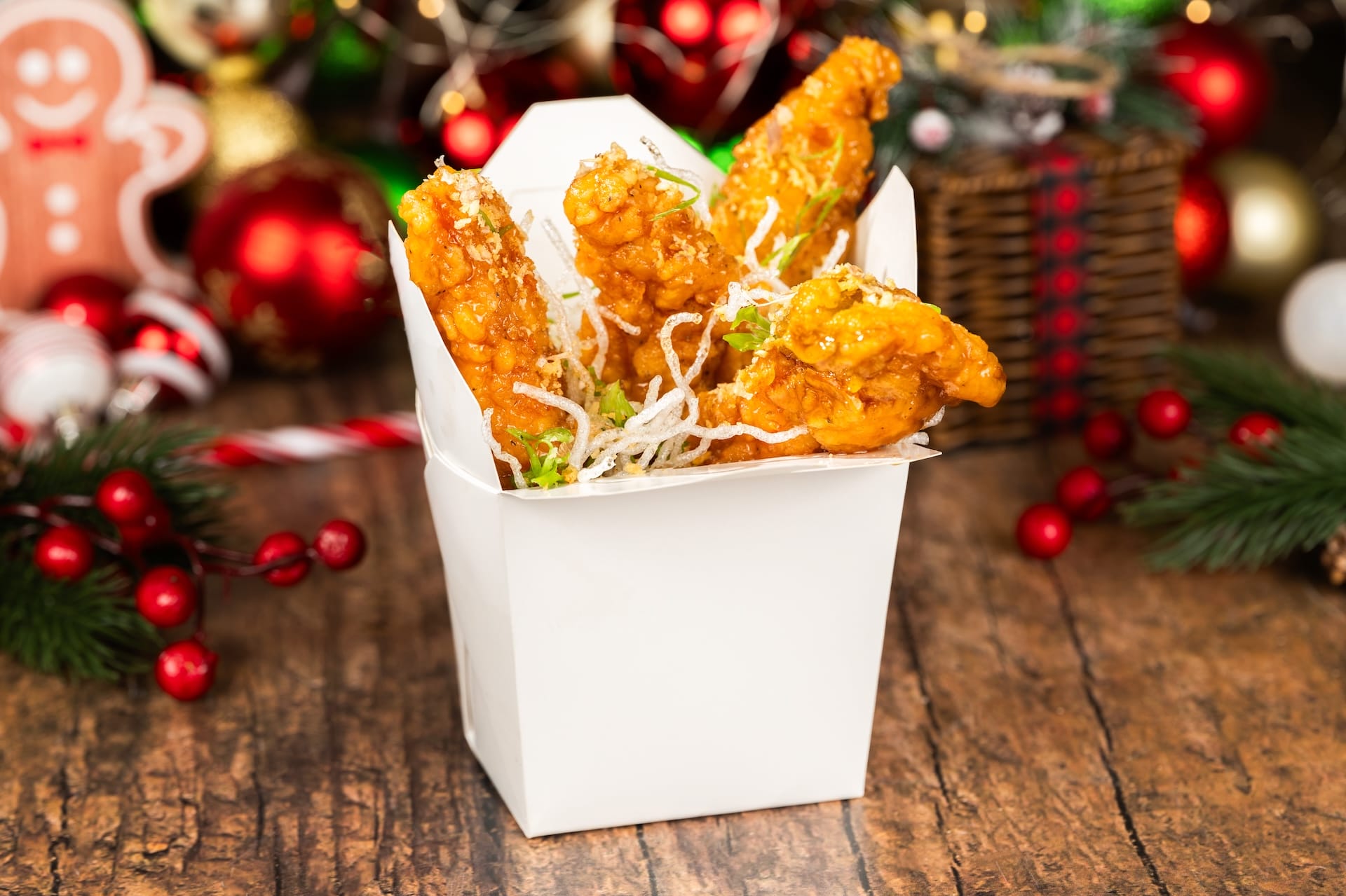 Golden fried chicken served in a white takeout box, ready to enjoy during Mickey’s Very Merry Christmas Party at Disney World.