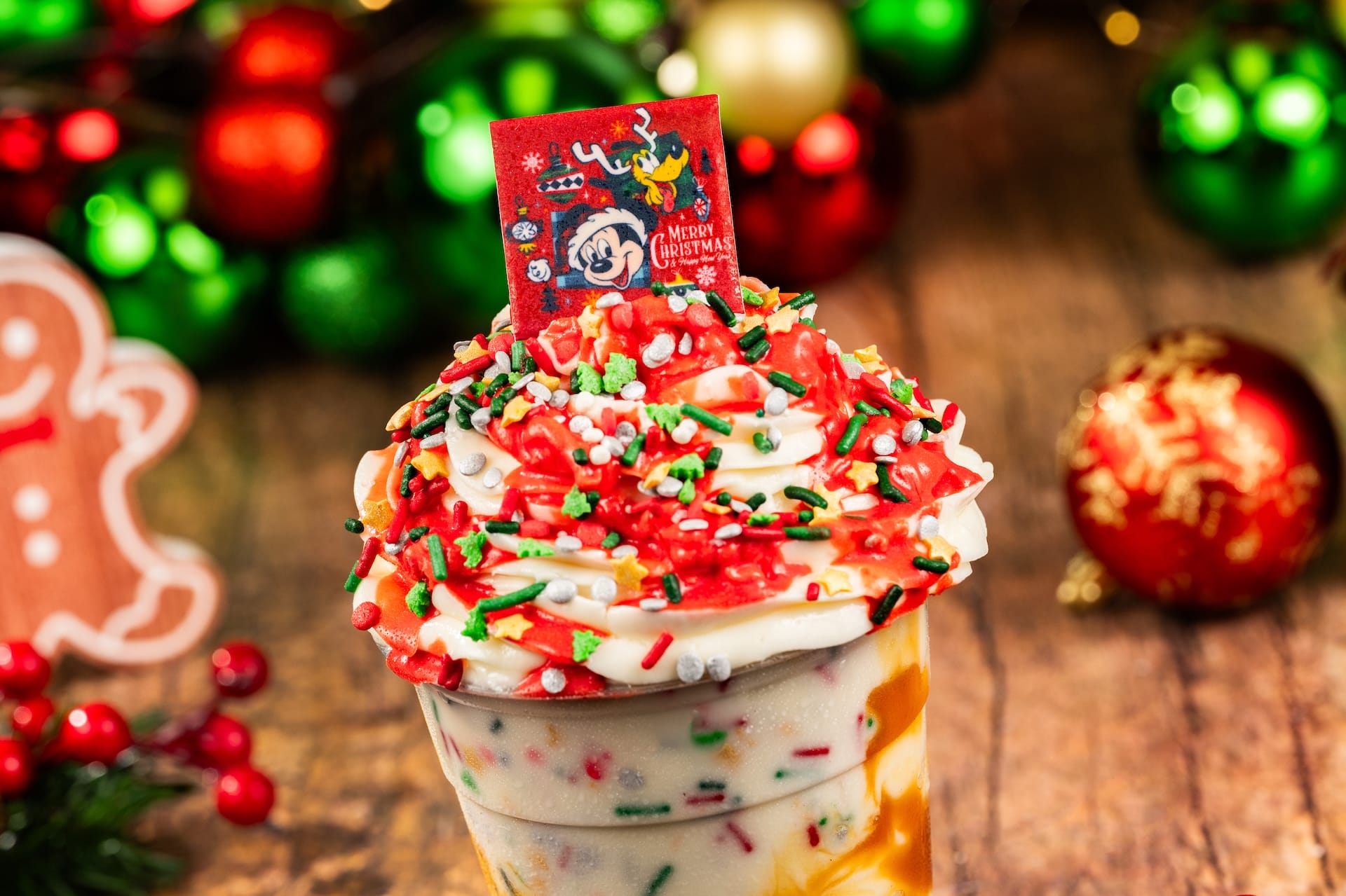 Holiday ice cream sundae from a Disney park, topped with red and green sprinkles and a Mickey Merry Christmas topper.
