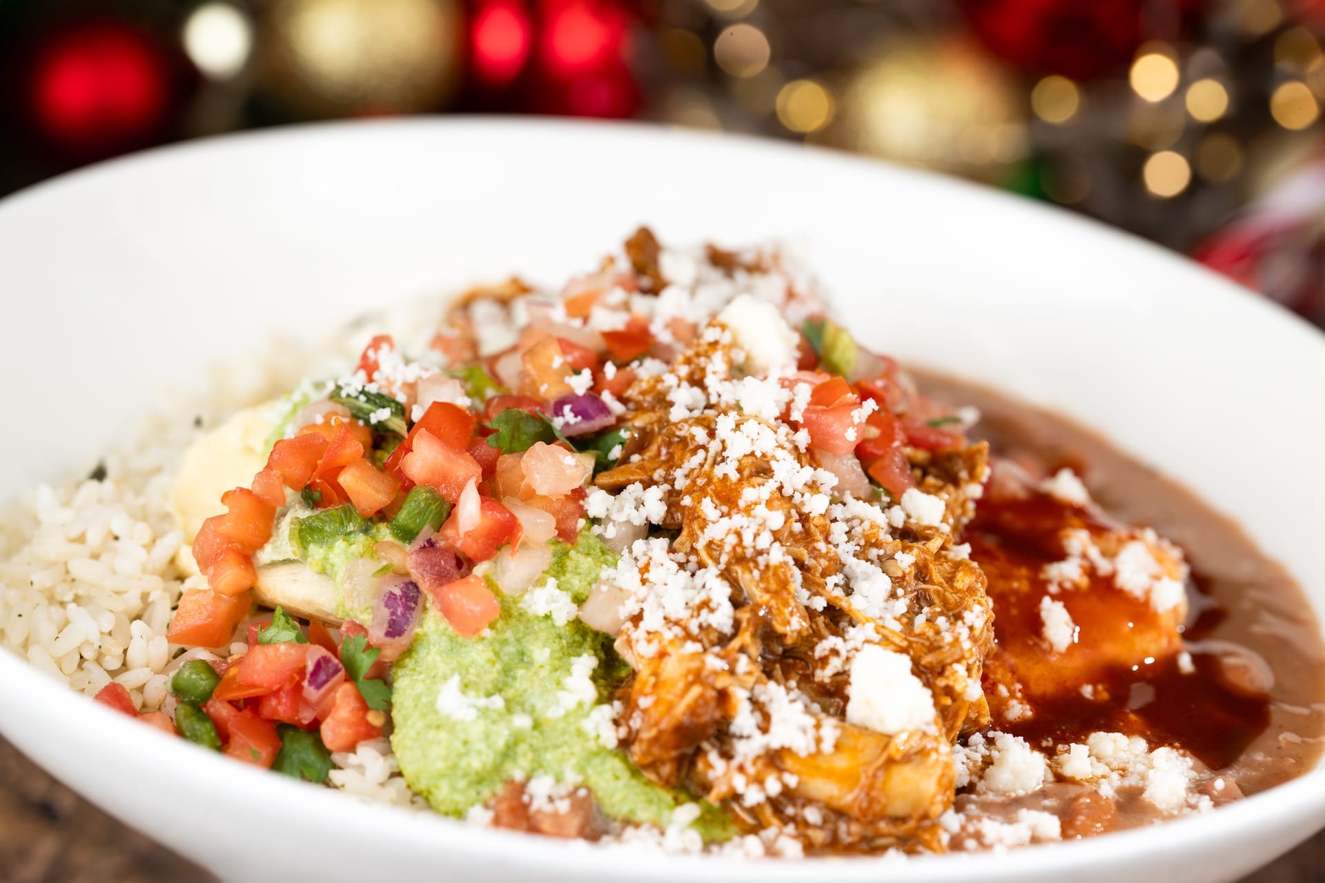 A white bowl of rice, beans, meat, salsa & guac glows under festive lights at Disney, rivaling the magic of their holiday castles.