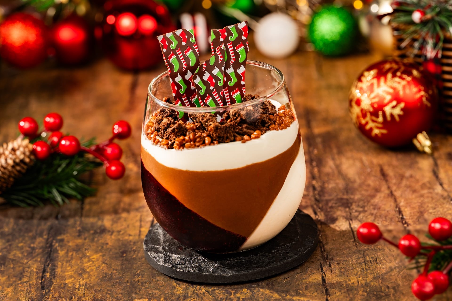 Festive dessert layered in a glass with chocolate, cream, and crumble; holiday Disney decor reminiscent of Main Street at Magic Kingdom.
