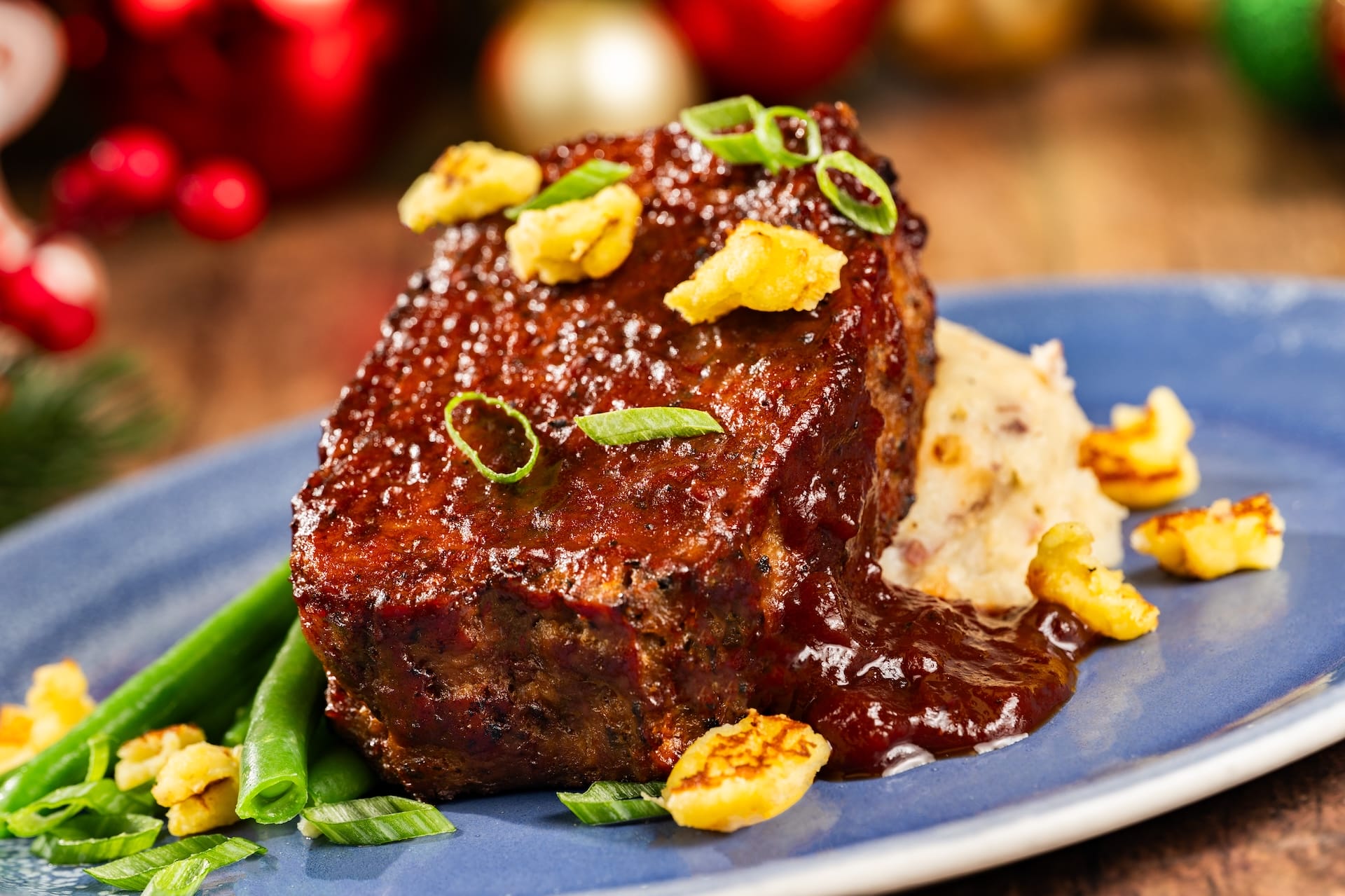 Glazed meatloaf slice with festive sides from the 2025 menu, served for Mickey’s Very Merry Christmas Party at a Disney park.