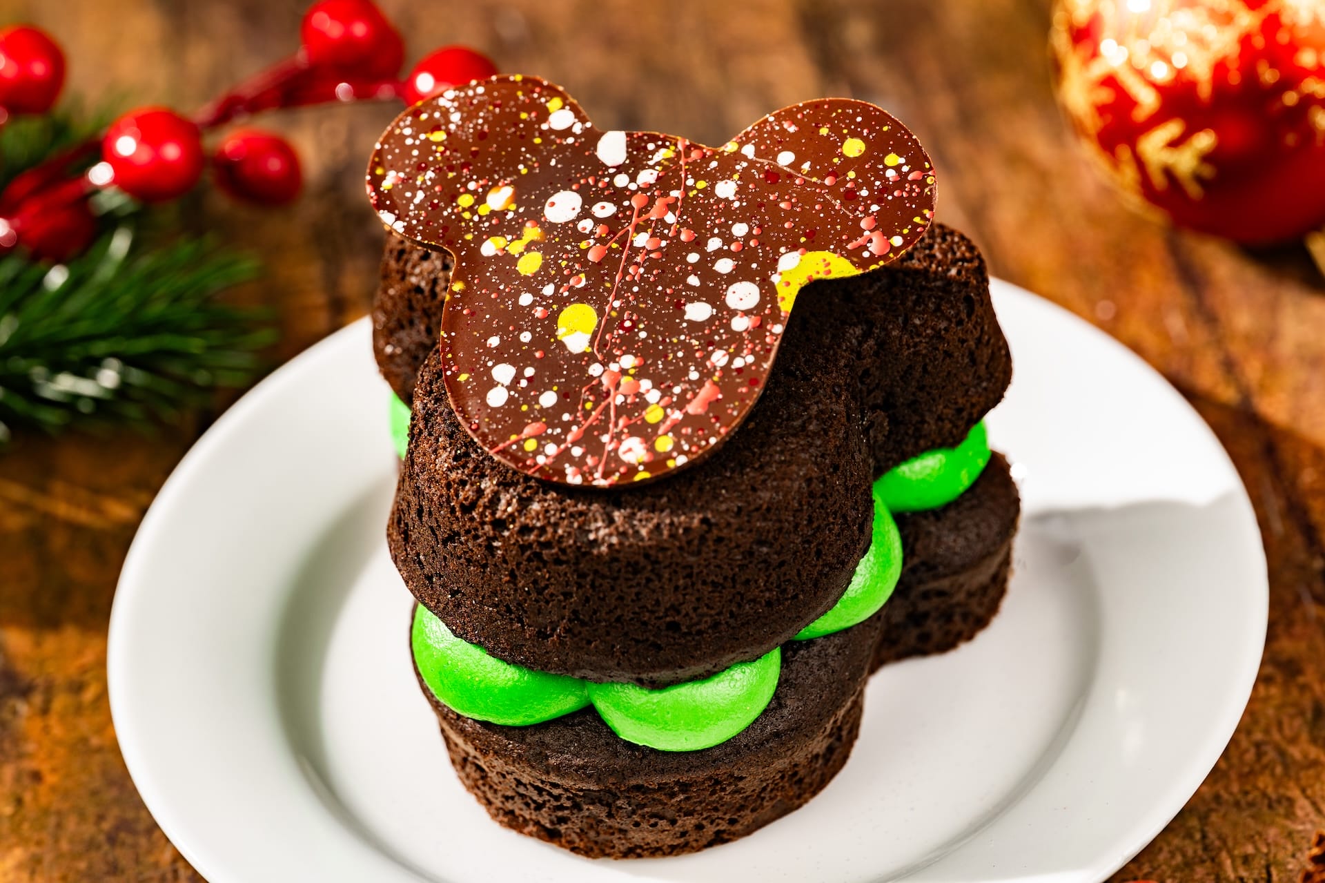 Festive Mickey-shaped chocolate cake with green filling from the 2025 party menu at Magic Kingdom, Walt Disney World.