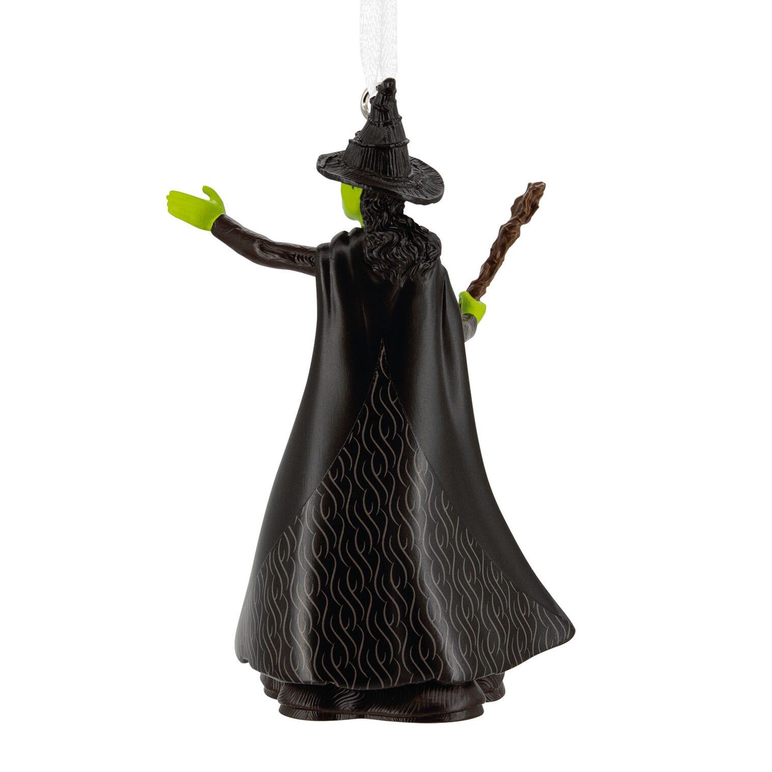 A Hallmark Ornaments witch figurine, with green skin, black hat and cape, holding a staff, back view.