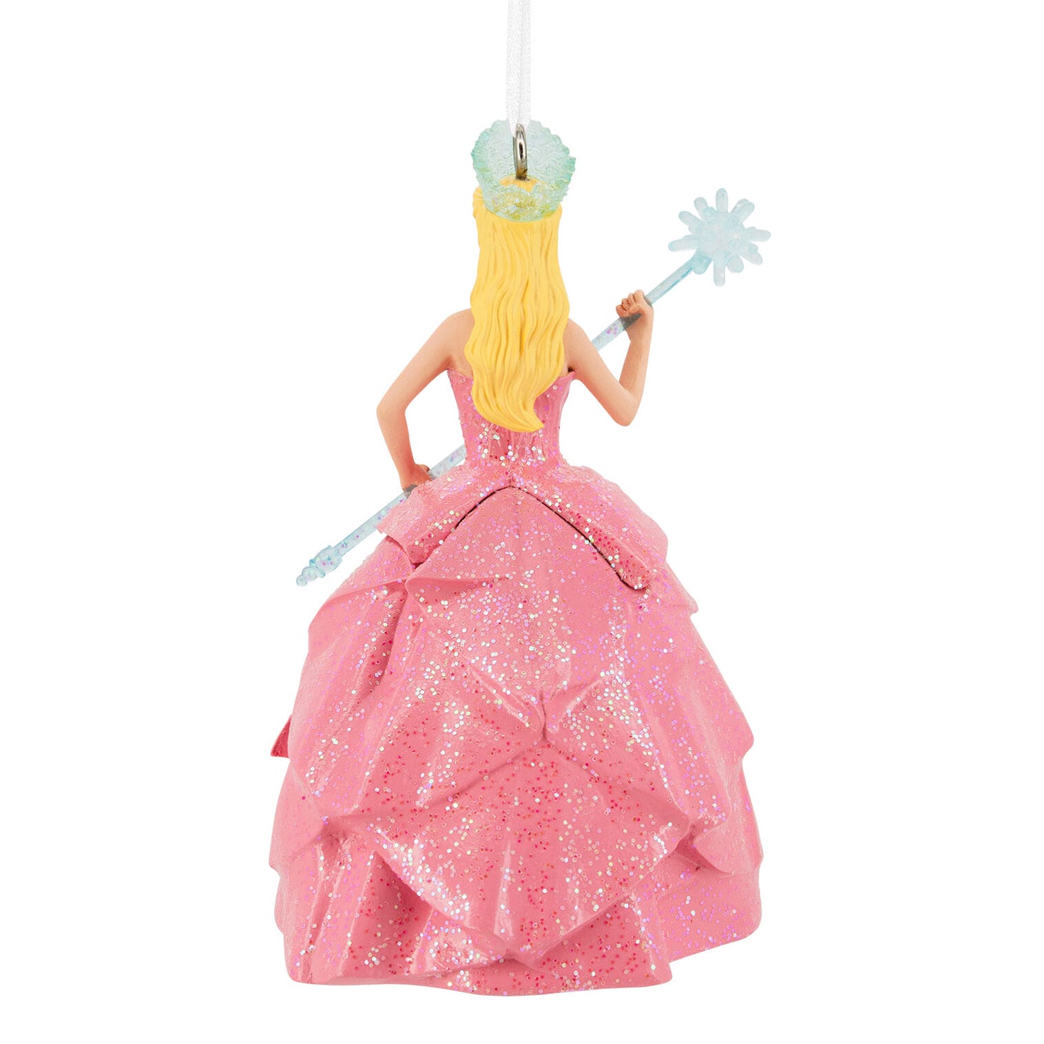 A glittery pink princess Hallmark ornament with a crown and wand hangs by a white string