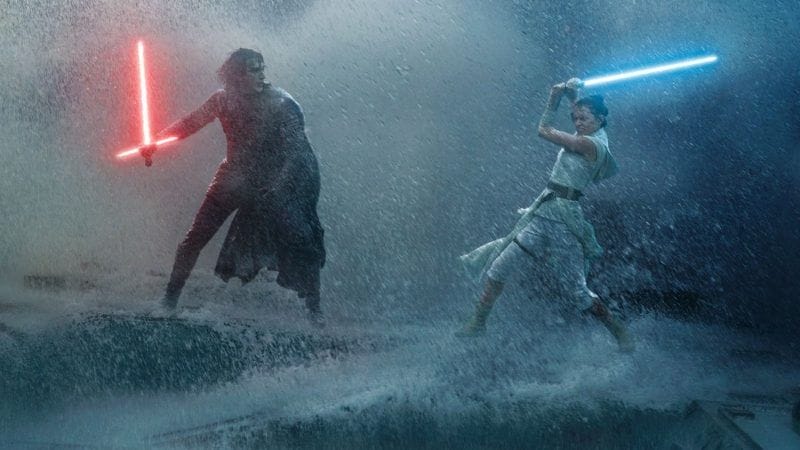 Two people duel with red and blue lightsabers on a stormy platform, reminiscent of Disney’s Star Wars: Galaxy’s Edge at night.