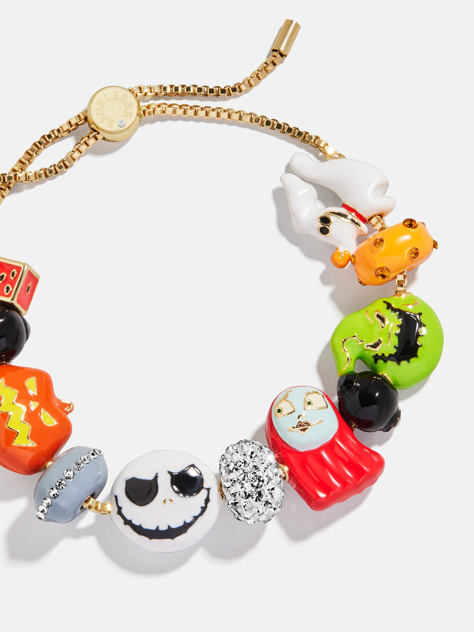 Gold bracelet with colorful Halloween charms, like pumpkins and ghosts, similar to festive jewelry sold at Disney Parks during Halloween.