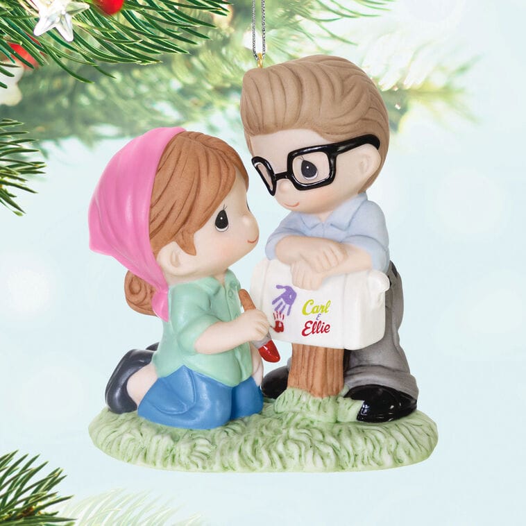Hallmark Disney Keepsake Ornament of a girl and boy carving "Carl + Ellie" on a mailbox, inspired by Disney Parks’ charm.