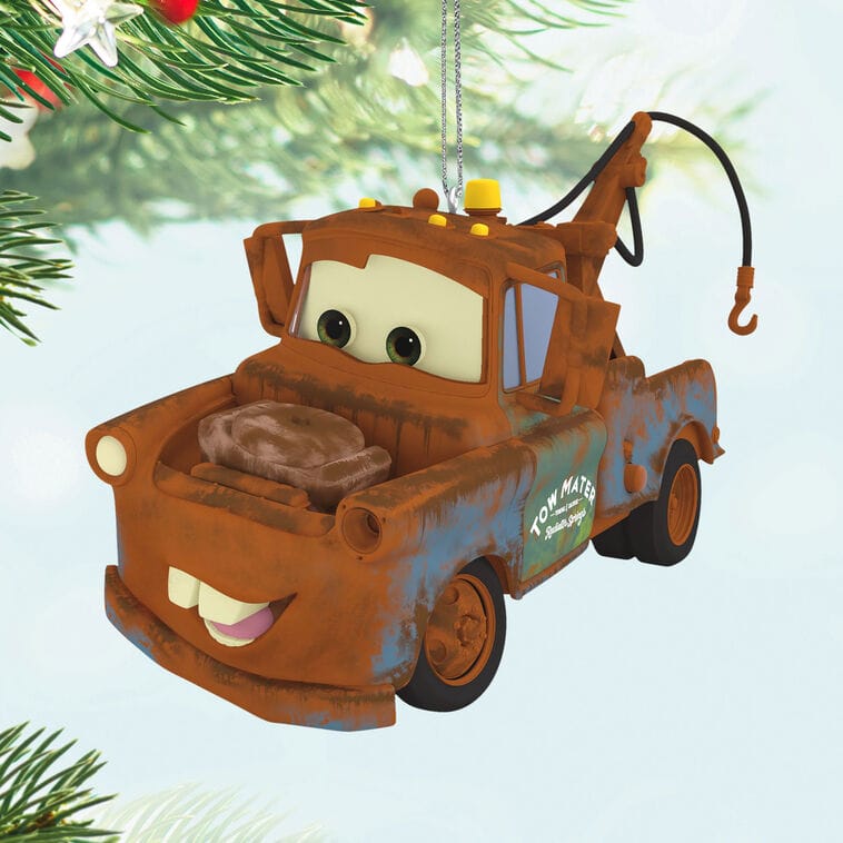 A Hallmark Disney Keepsake Ornament of Mater hangs on a Christmas tree, conjuring holiday magic like Main Street in the Disney parks.