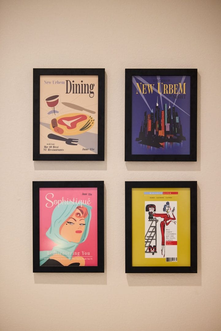 Four framed art prints on a beige wall, styled like Disney Parr House, each evoking Disneyland parks’ iconic magazine-like covers.