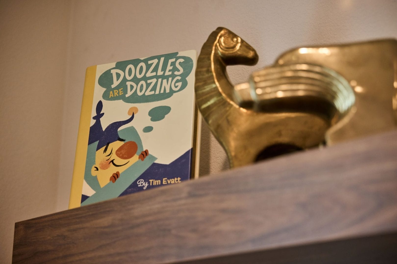 In the Disney Parr House, "Doozles Are Dozing" by Tim Evatt sits beside a gold figurine, reminiscent of Disney park decor.