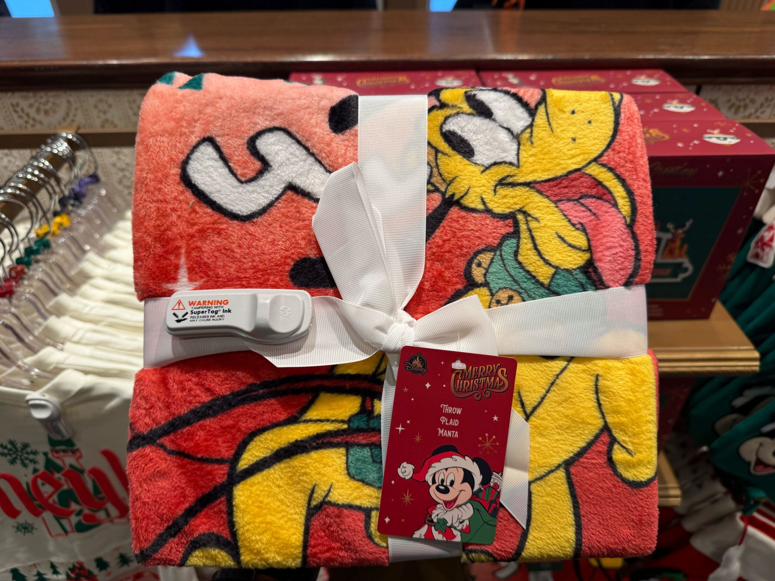 A rolled-up Disney fleece throw featuring Pluto, from the 2025 Disneyland Christmas merchandise collection.