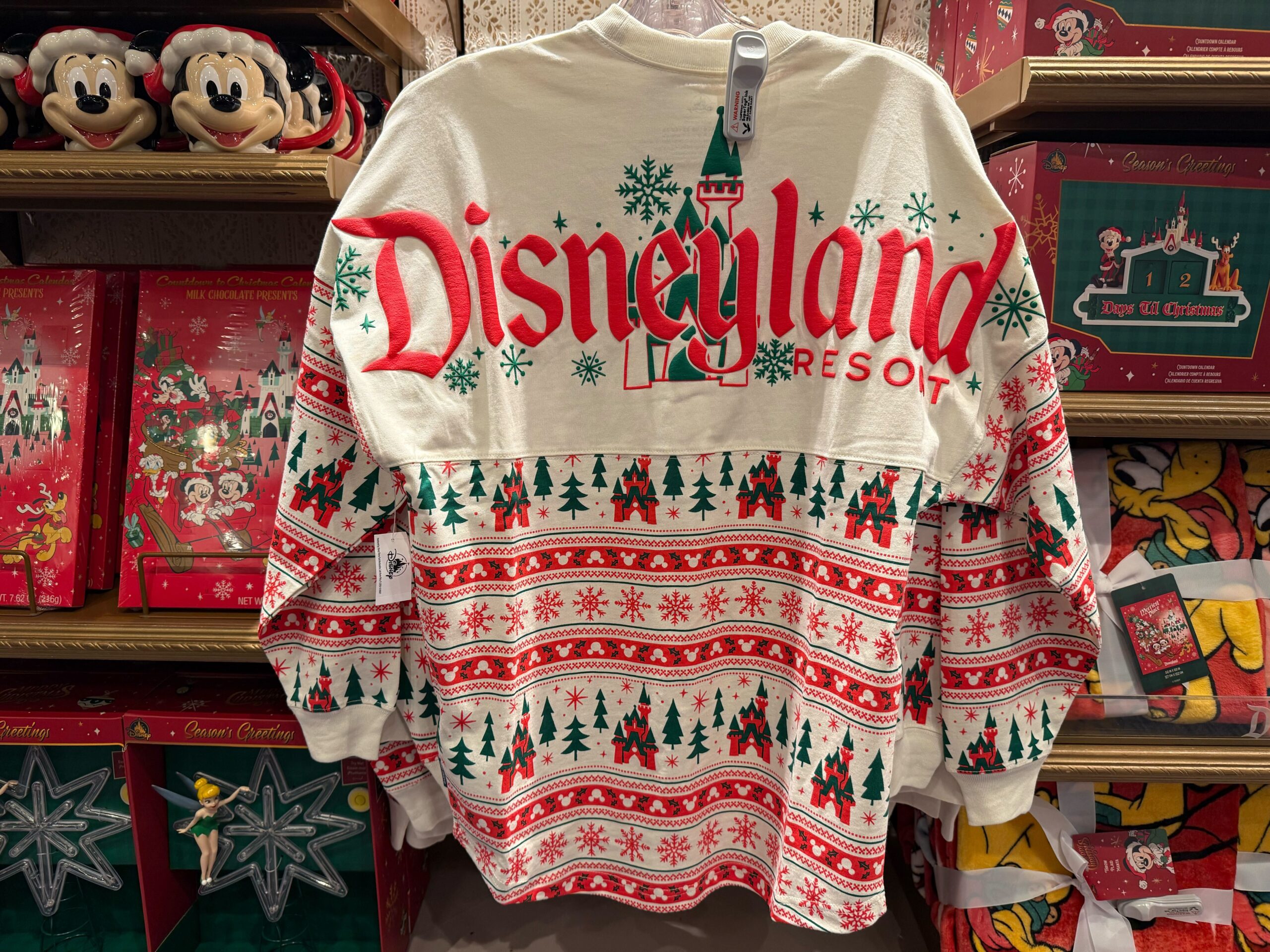 A Disneyland Christmas merchandise holiday sweater features festive patterns and castle designs, perfect for 2025 celebrations.