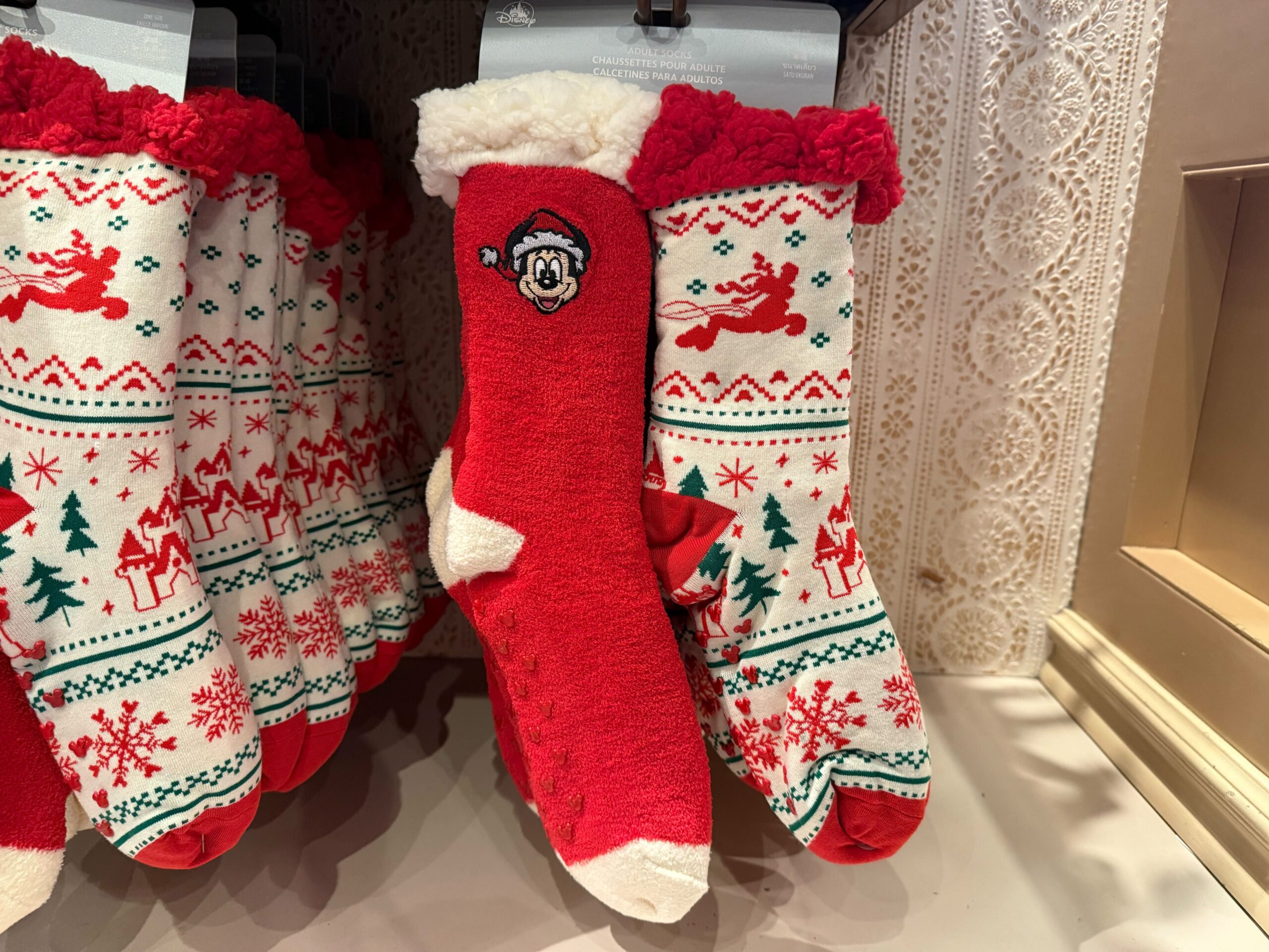Red and white festive socks with Disney’s Mickey Mouse in a Santa hat, part of 2025 Disneyland Christmas merchandise.