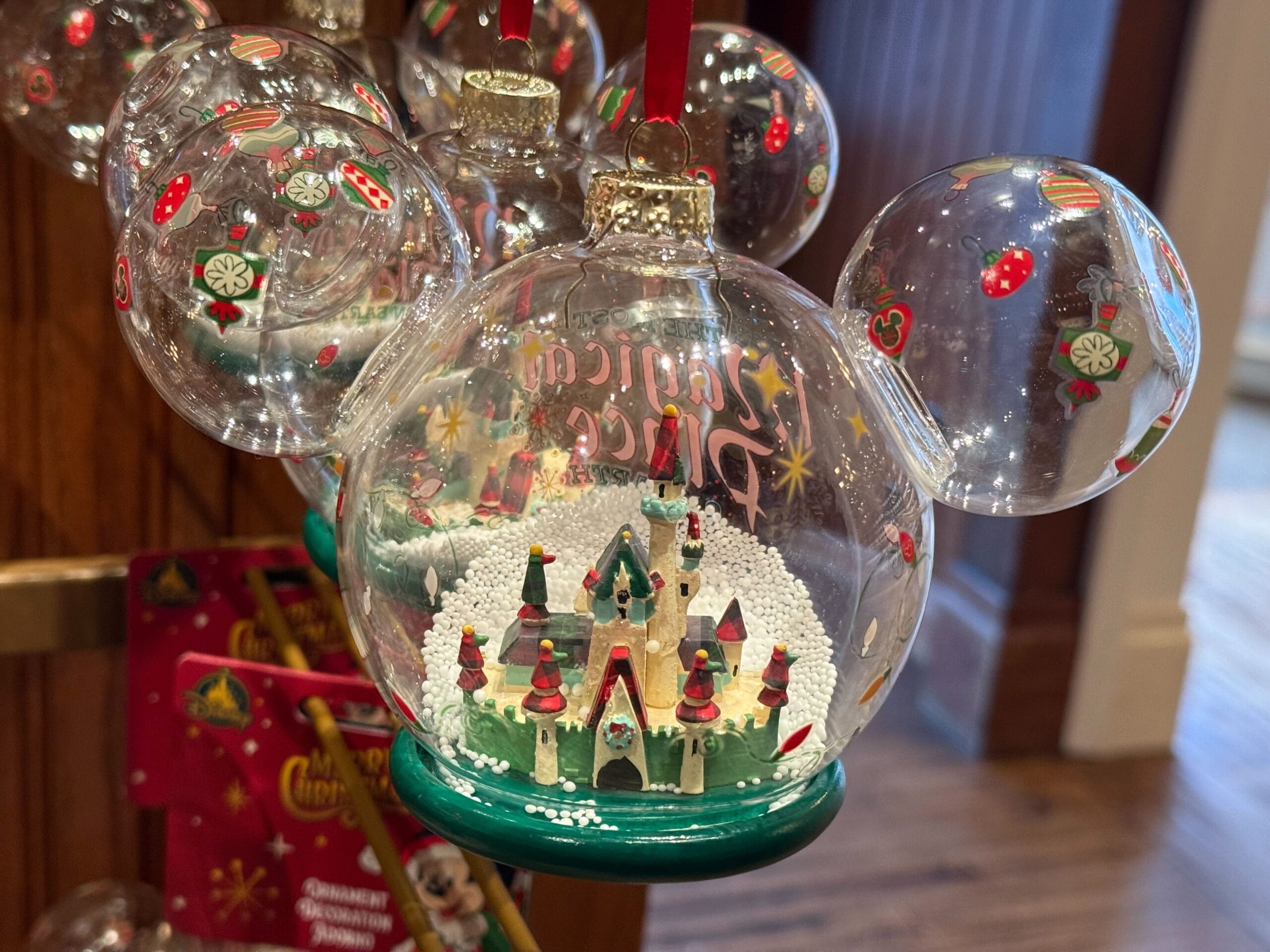 Mickey-shaped ornament featuring a festive castle and snow, part of 2025 Disneyland Christmas Merchandise.