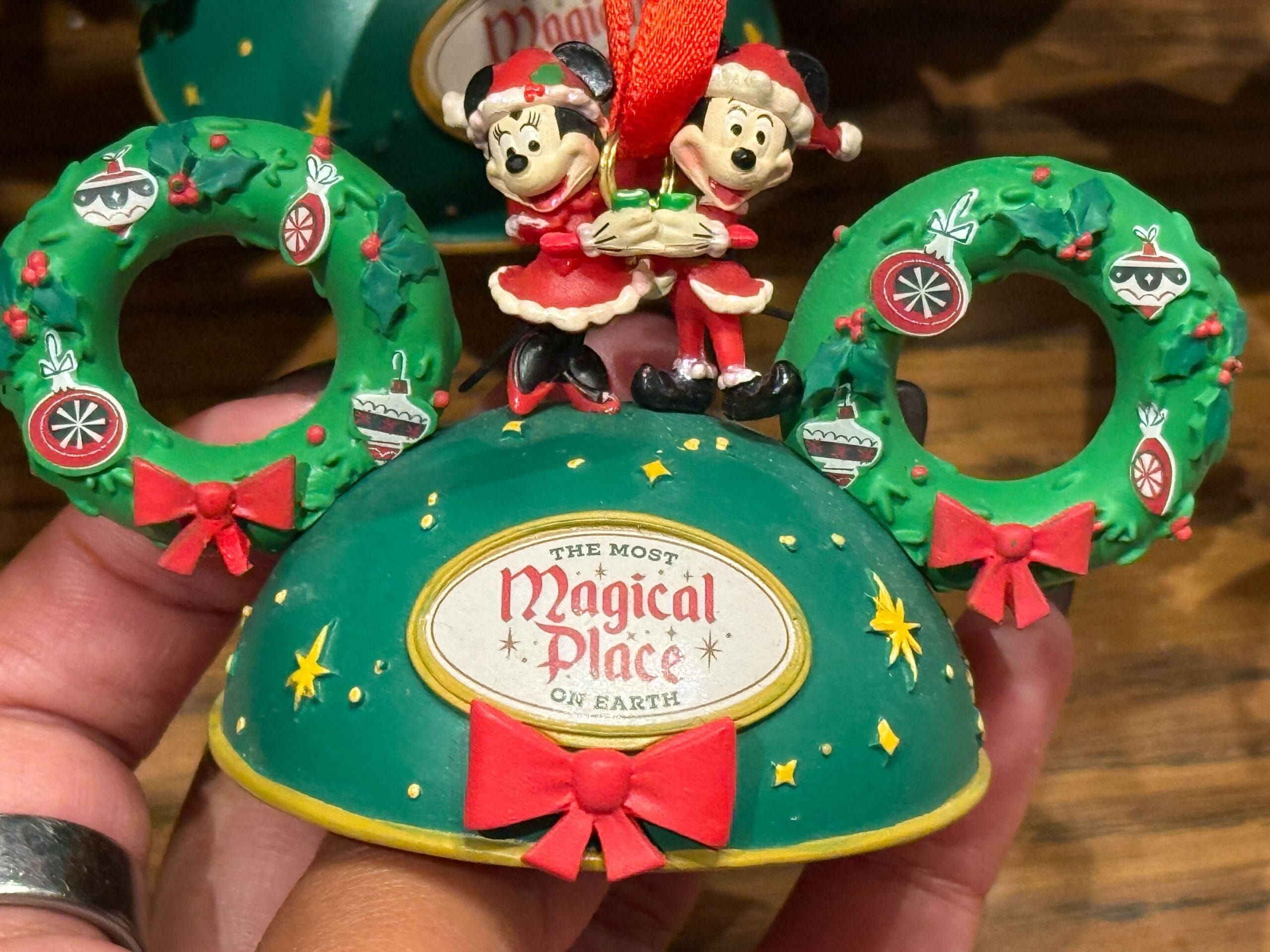 Green Mickey ears ornament featuring Minnie and Mickey in Christmas outfits, part of Disneyland Christmas merchandise 2025.