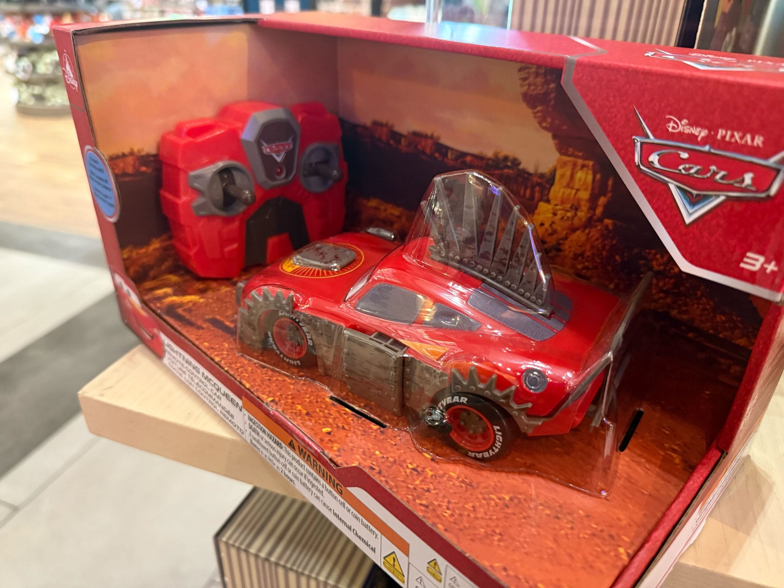 Lightning McQueen remote-control car in a red Disney Pixar Cars box with matching controller, like toys found at Disneyland shops.