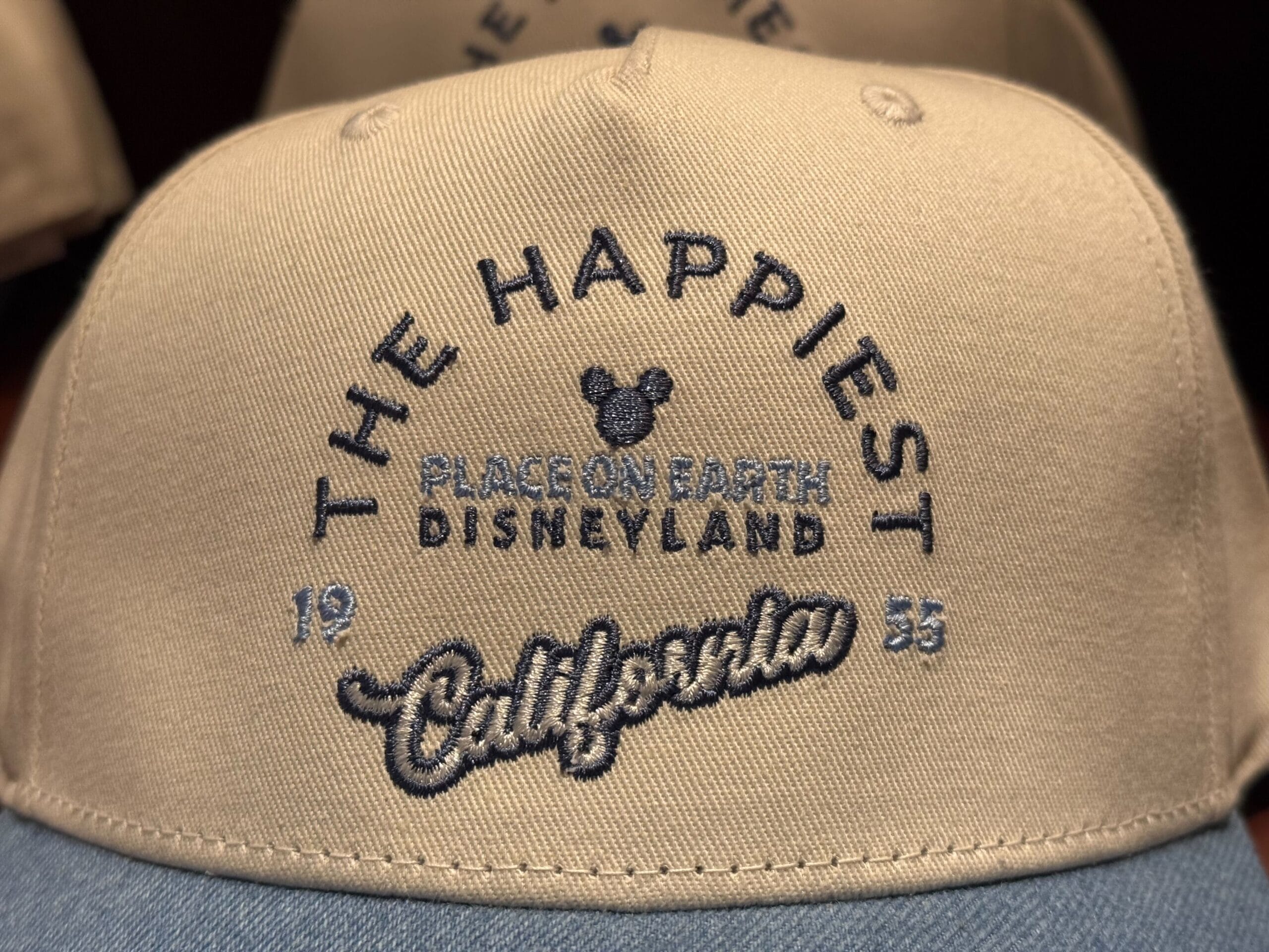 Classic Disneyland beige hat with blue embroidery, featuring "The Happiest Place on Earth 1955," a nod to the original Anaheim park.