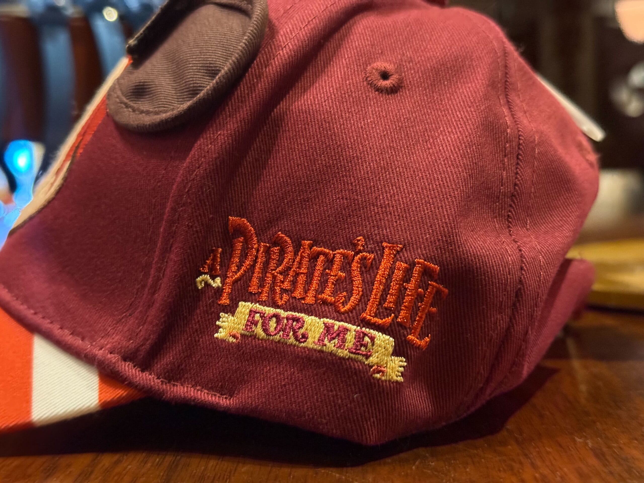 A maroon cap with gold and red embroidery, classic Disneyland merch—great for collectors at any Disney park around the world.