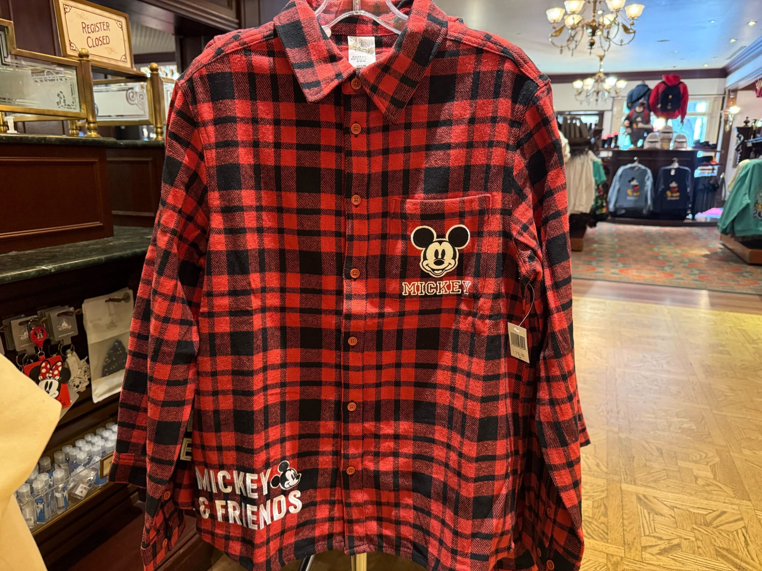 Red and black plaid shirt featuring Mickey Mouse graphics, a playful Disneyland Parks merchandise find, spotted in a shop display.