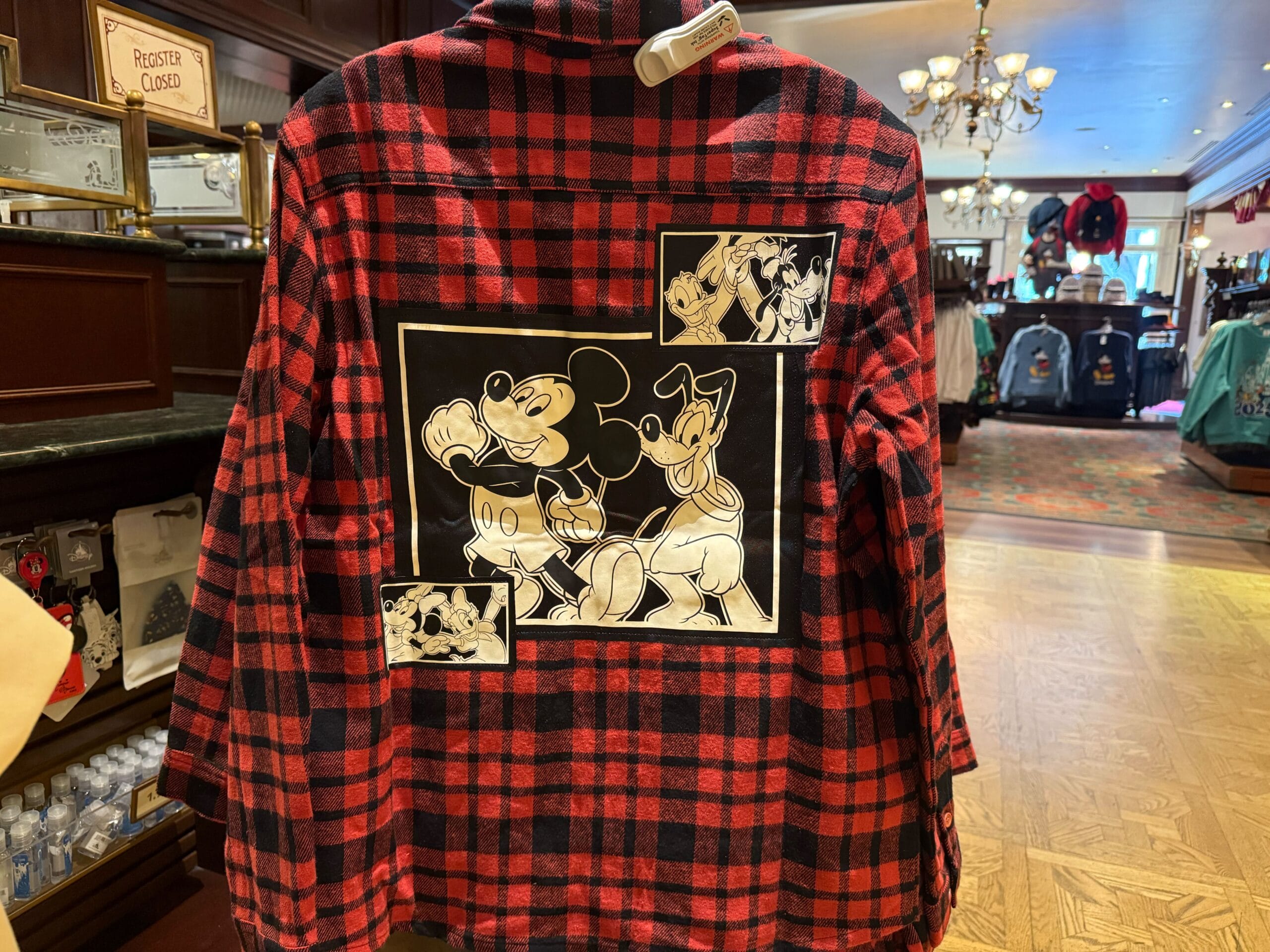 Red plaid shirt featuring black and white Mickey, Donald, and Goofy designs—a sought-after Disneyland park exclusive merch item.