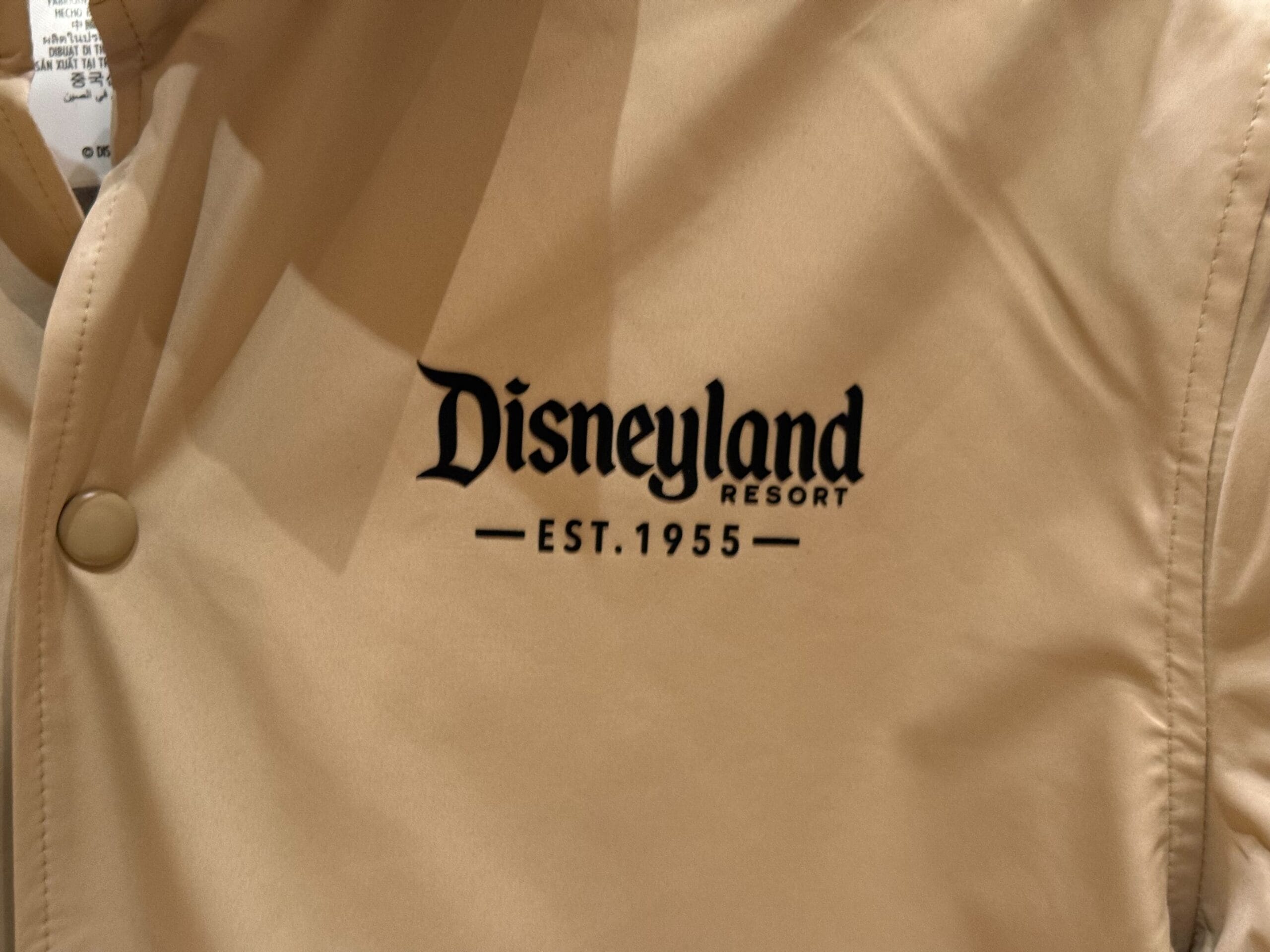 Beige jacket with "Disneyland Resort Est. 1955" in black—a nod to Anaheim's original park, not to be confused with Magic Kingdom.