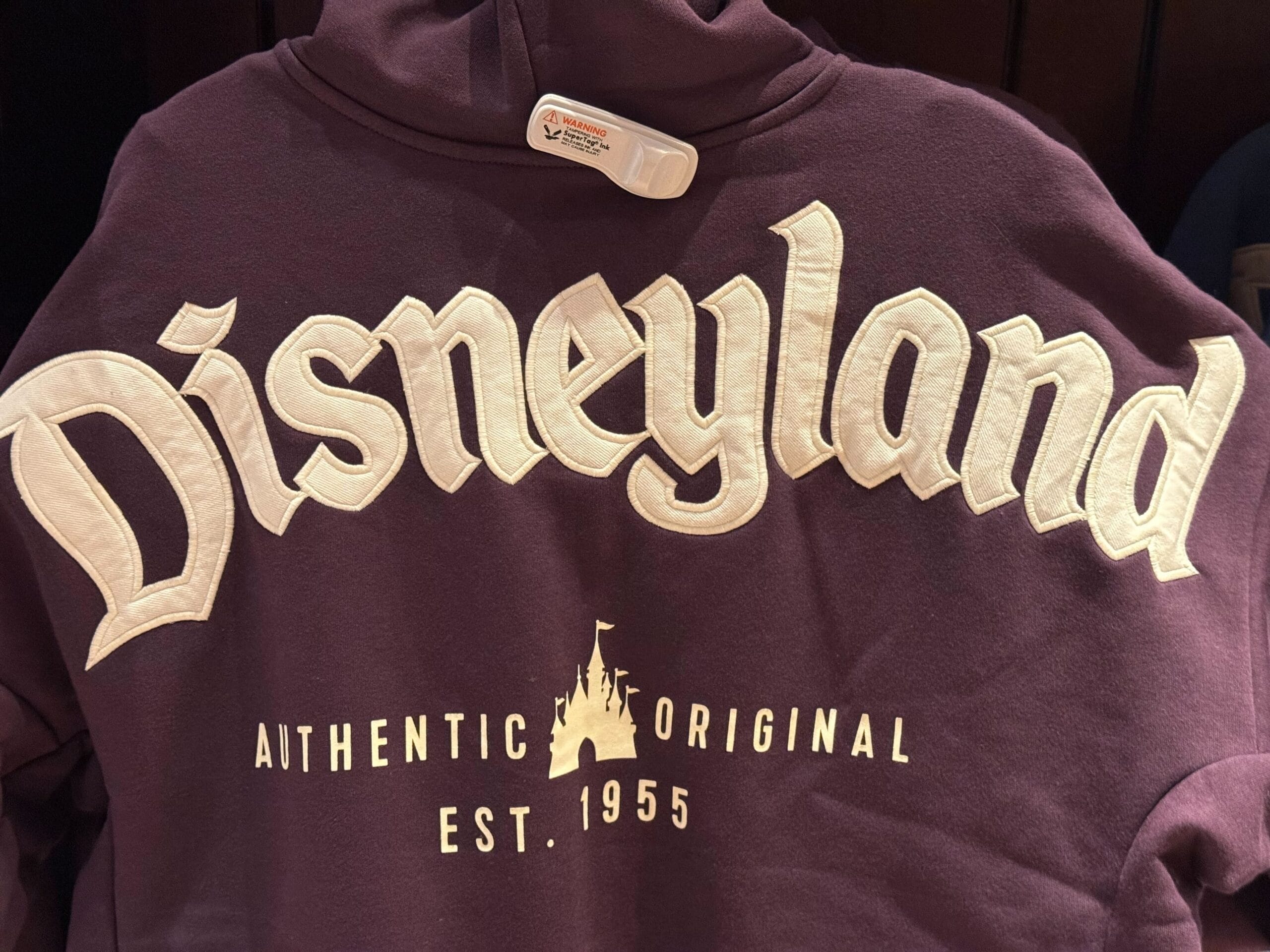 A maroon Disneyland hoodie with "Authentic Original Est. 1955," perfect for fans of any Disney Park, from Anaheim to Paris.