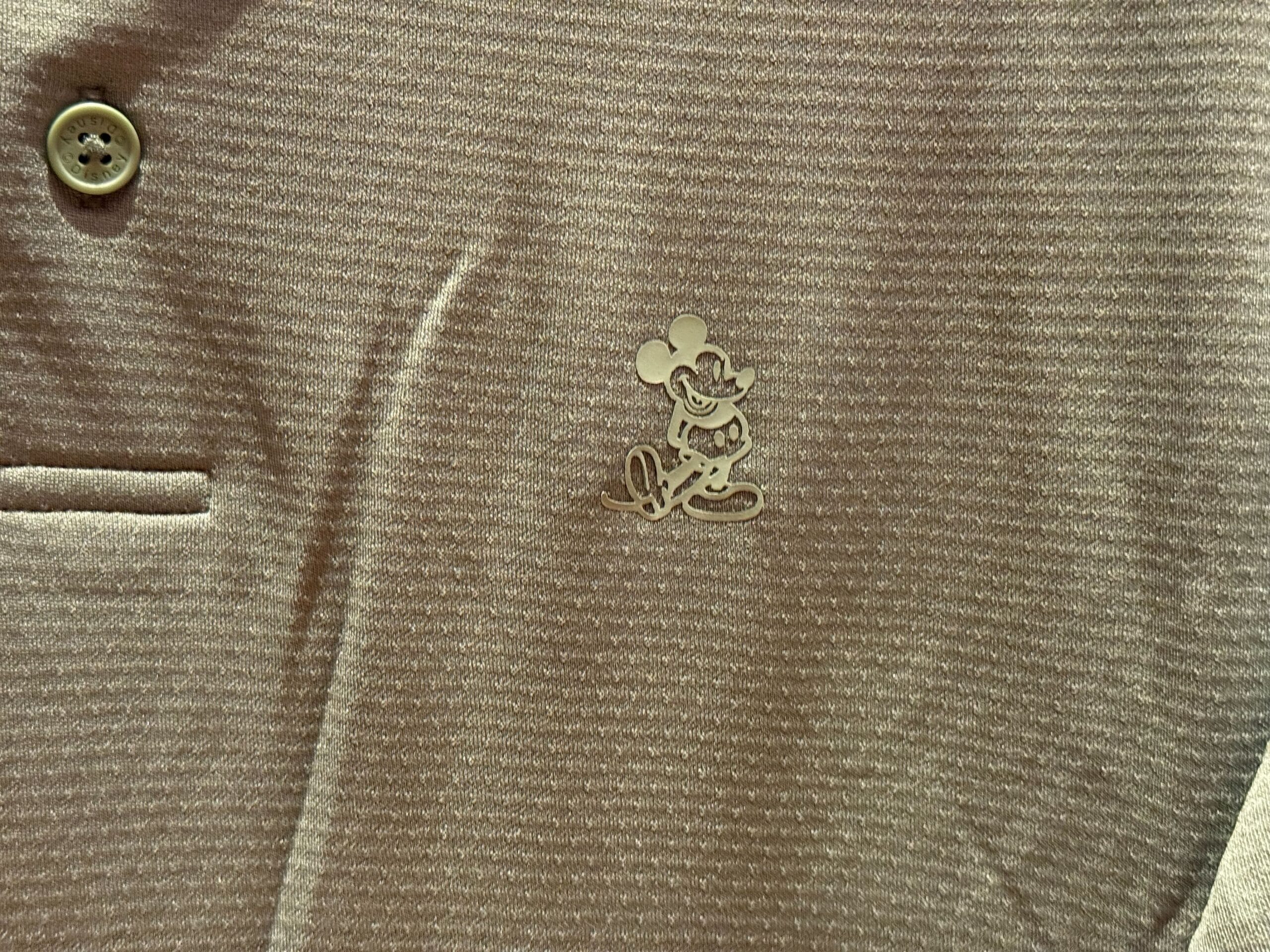 A close-up of a shirt featuring a small embroidered Mickey Mouse, a popular Disney Park souvenir at Disneyland and other parks worldwide.