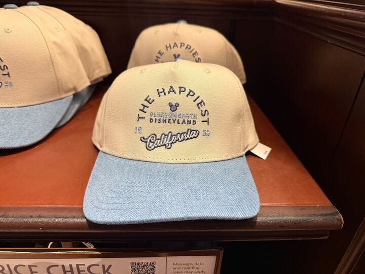 Tan and blue cap with "The Happiest Place on Earth" and Mickey, classic Disneyland merch—referencing the original Anaheim park.