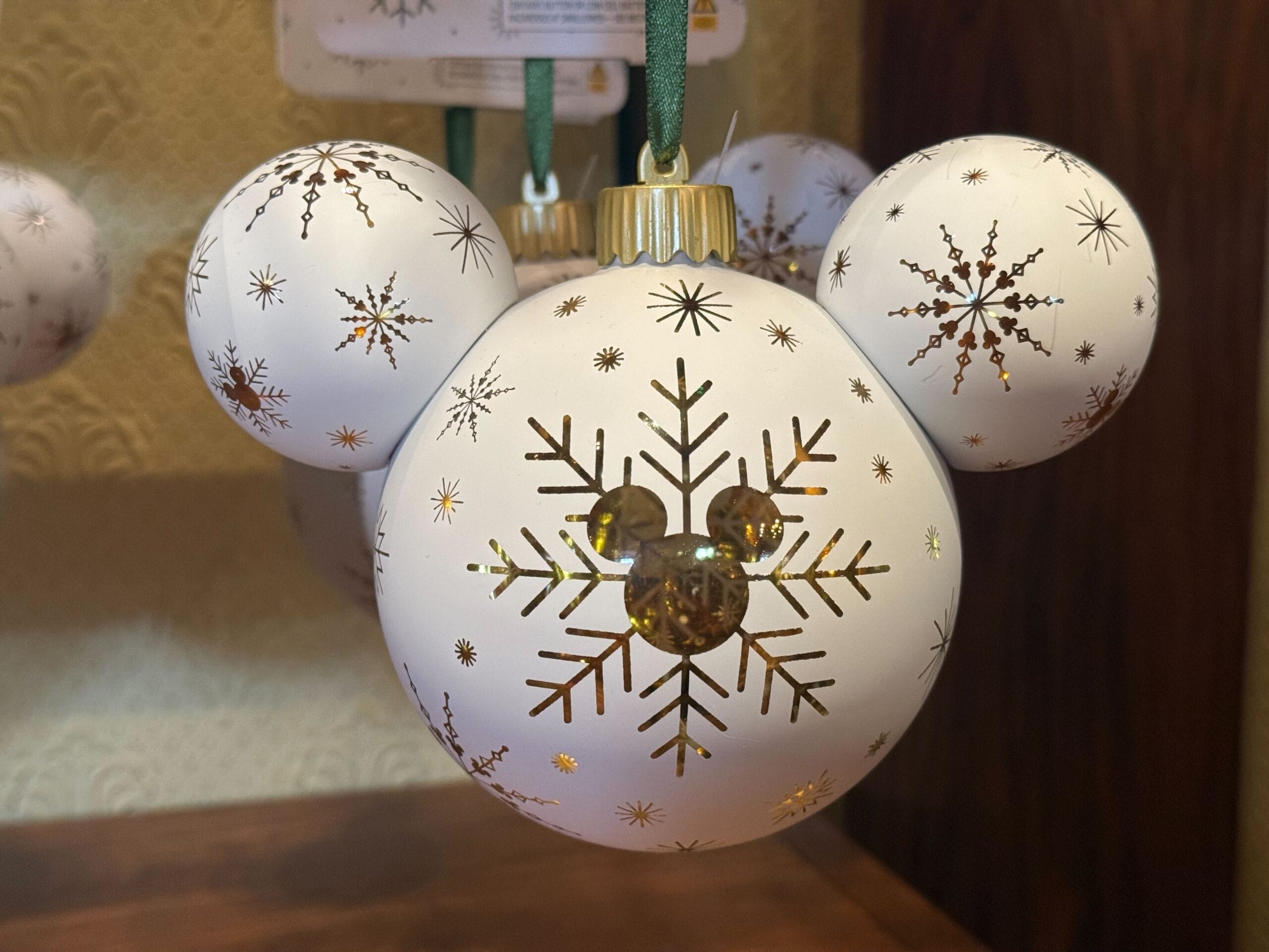 White Mickey Mouse-shaped ornament adorned with gold snowflakes, a 2025 Disneyland exclusive—capturing the park’s festive spirit.