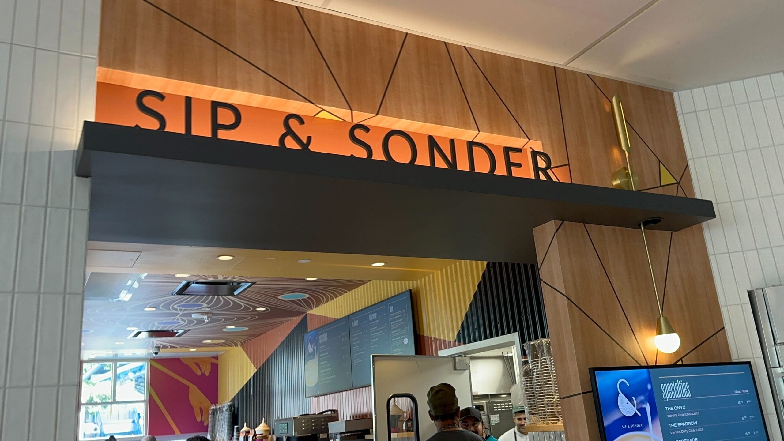 Sip & Sonder café entrance in Downtown Disney, featuring modern decor; closed. No castle like Disneyland’s nearby in this view.