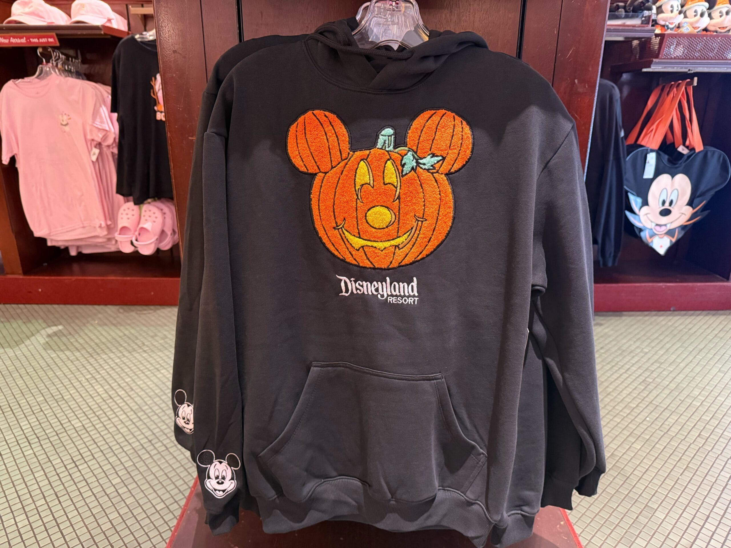 Black Disneyland Resort hoodie featuring a Mickey Mouse pumpkin; a festive design distinct from any park castle, great for Disney fans.