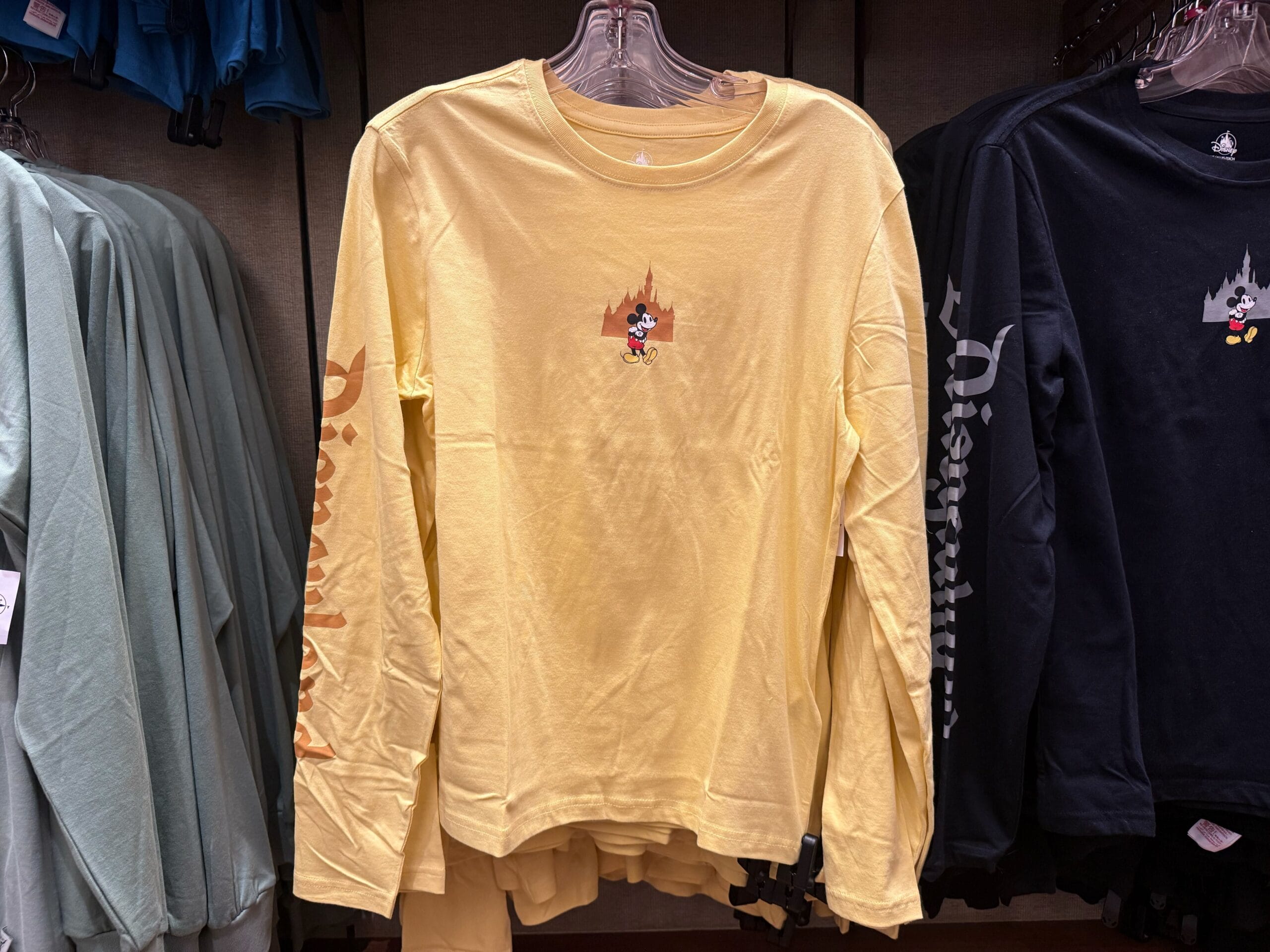Yellow Disneyland long-sleeve with Mickey Mouse and "Disneyland" on the sleeve, displayed in new arrivals—Disney Parks merch.