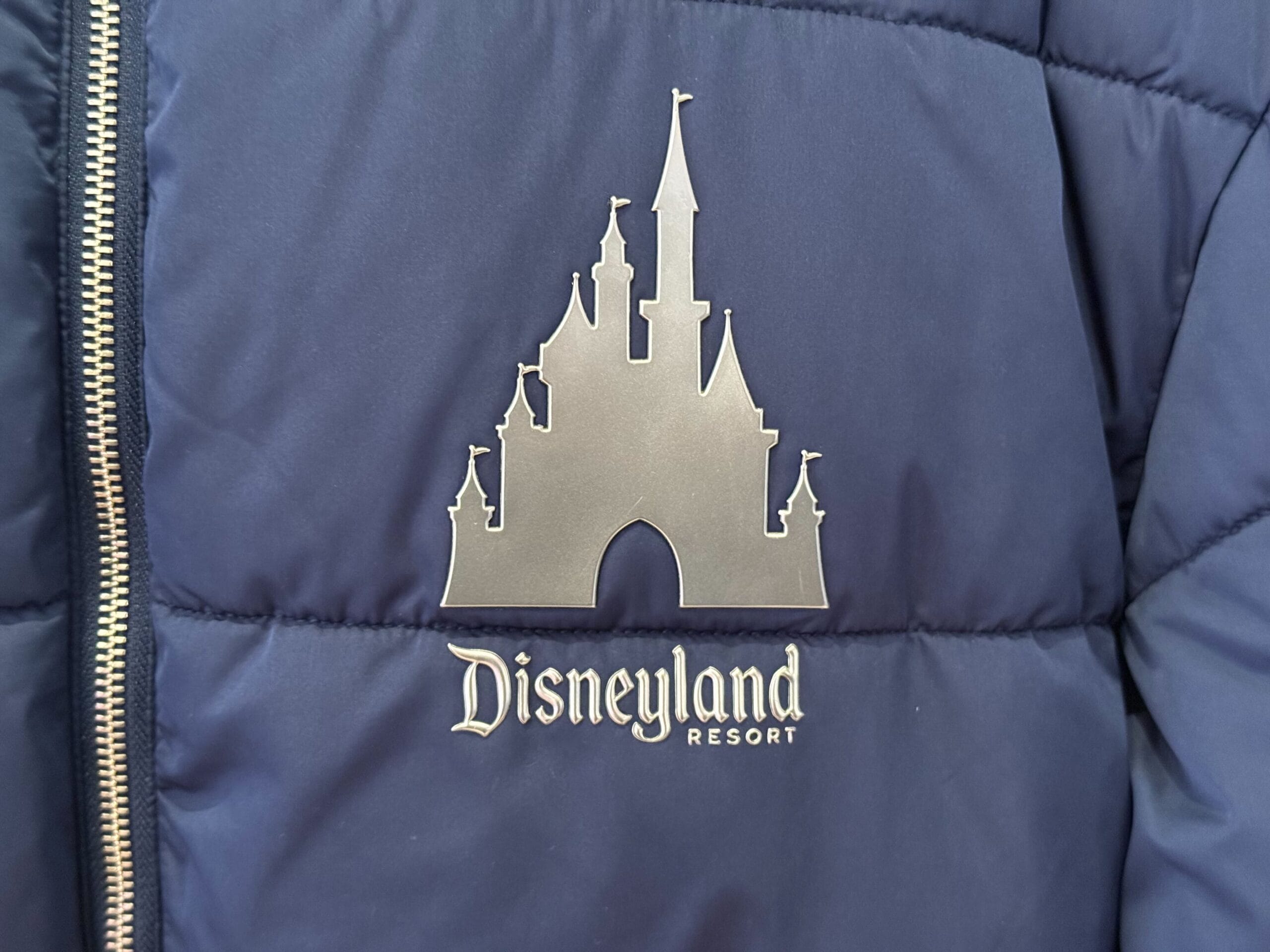 A navy jacket with a silver Disneyland Resort logo on the front, showing a castle stylized like the original Anaheim Disneyland castle.