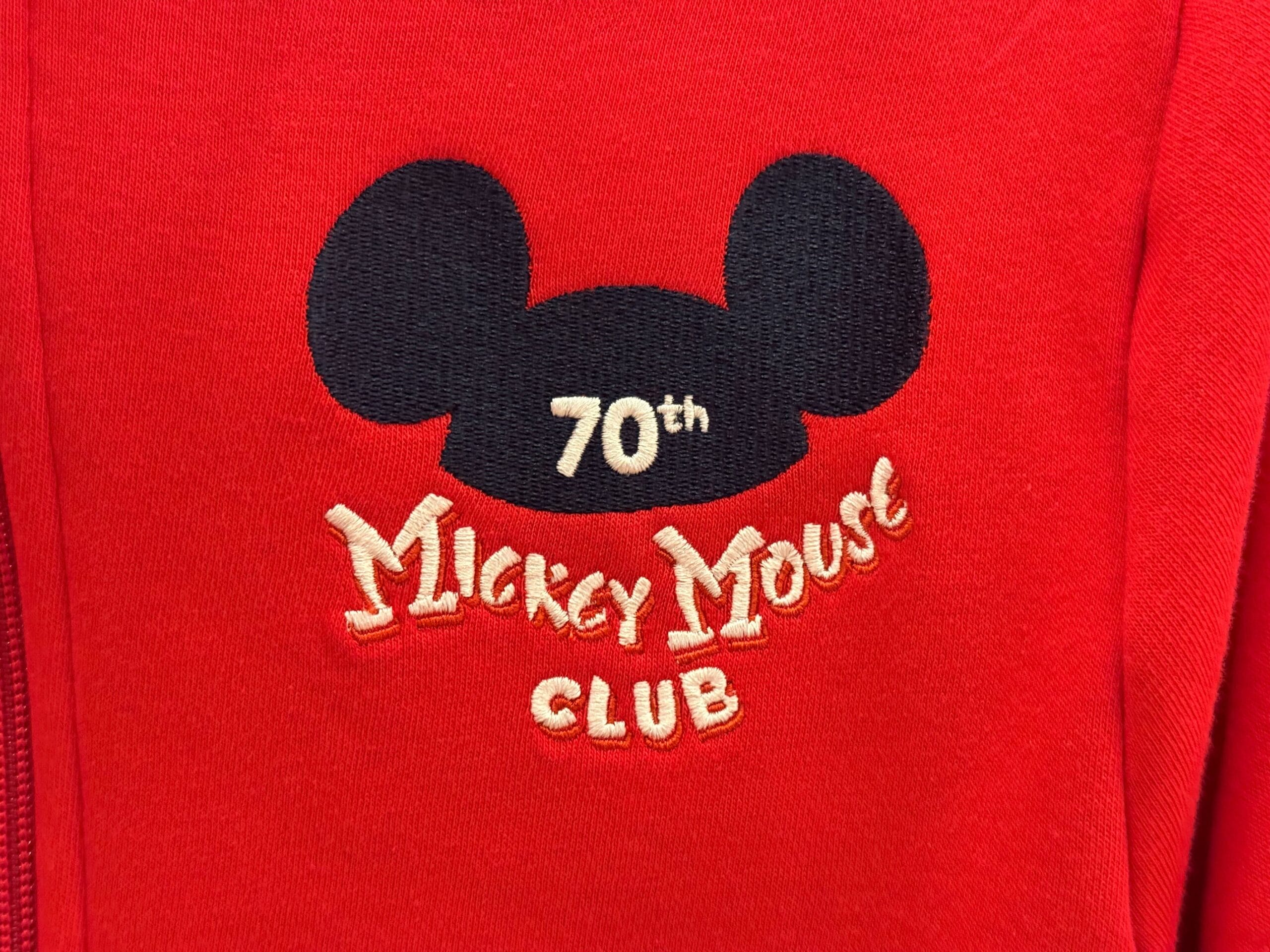 Red fabric with a black Mickey Mouse ears logo and "70th Anniversary Mickey Mouse Club" embroidered in white and yellow.