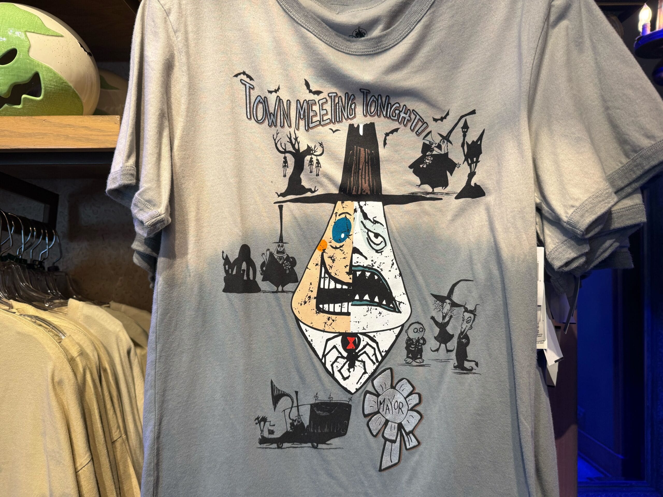 Gray t-shirt with quirky Nightmare Before Christmas art and “Town Meeting Tonight!”—a must-have for Disney Park fans.