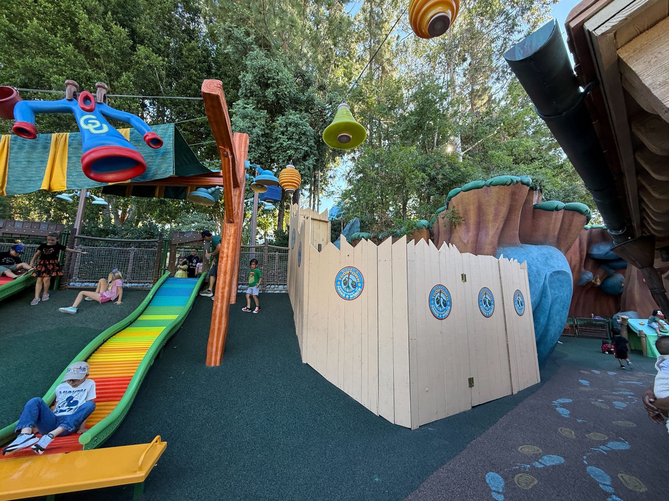 Kids enjoy bright slides near construction barriers at Disneyland’s Toontown playground, no castle visible in this scene.